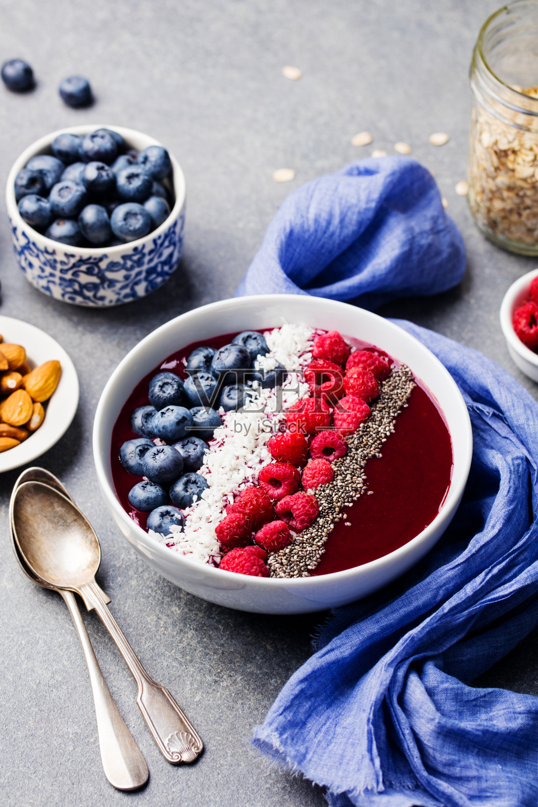 覆盆子蓝莓椰子片奇亚籽冰沙碗（灰色石材背景）照片摄影图片