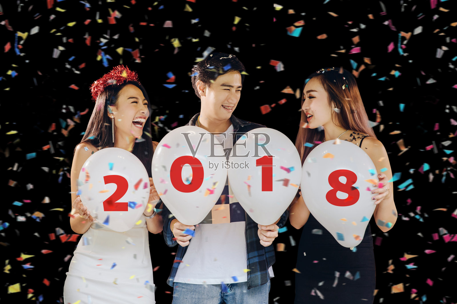 一群美丽的年轻亚洲人庆祝新年前夕，并拿着写有数字2018的气球。快乐搞笑概念照片摄影图片