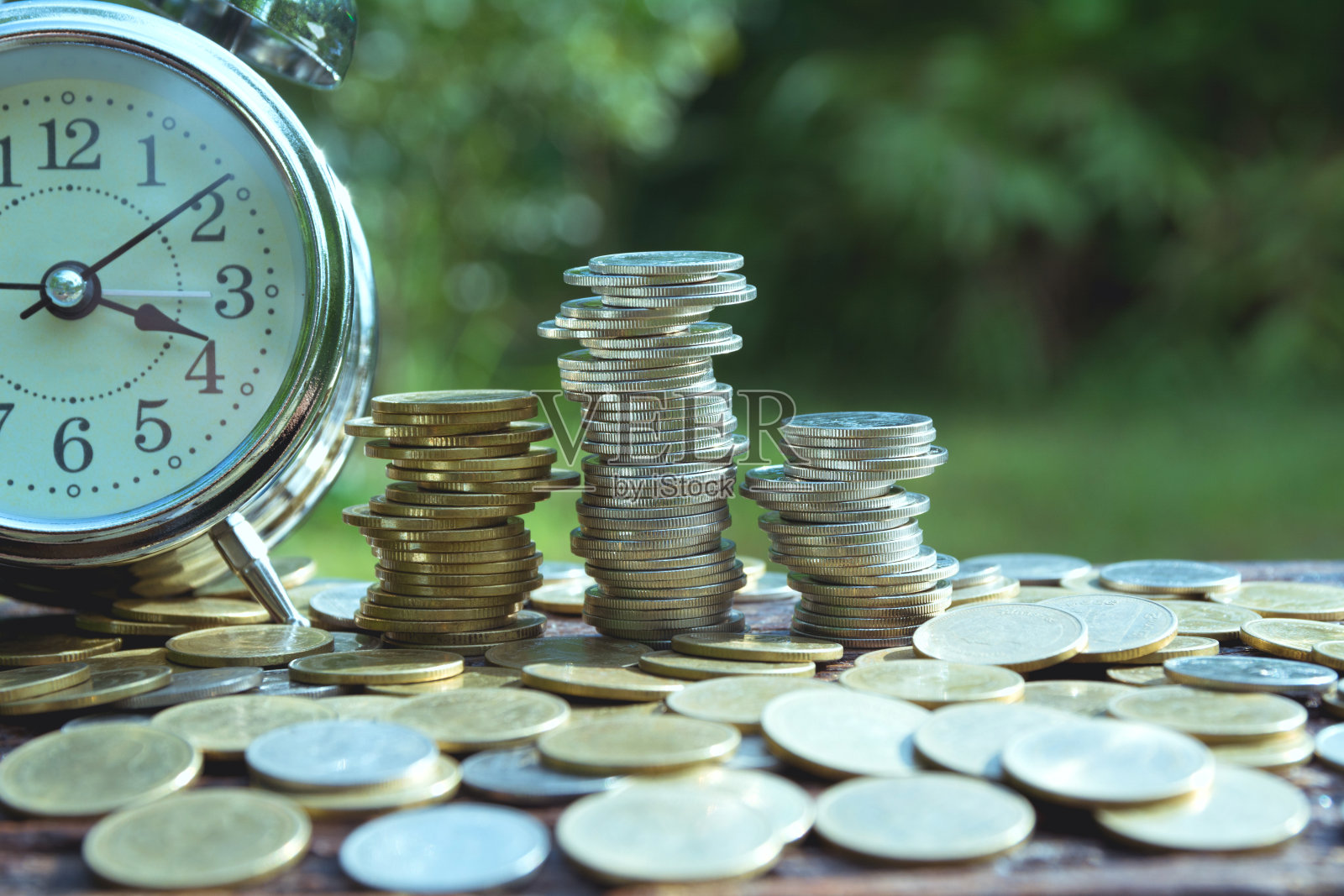 省钱的概念与货币堆叠增长和闹钟的业务。财务会计概念。照片摄影图片