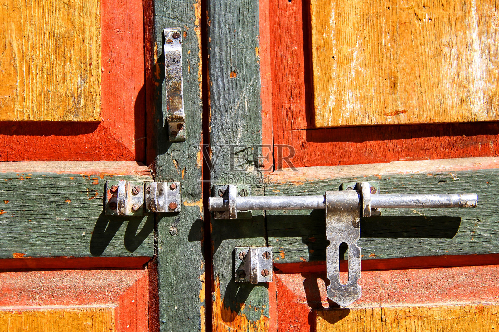 旧的彩色木门与金属螺栓。照片摄影图片