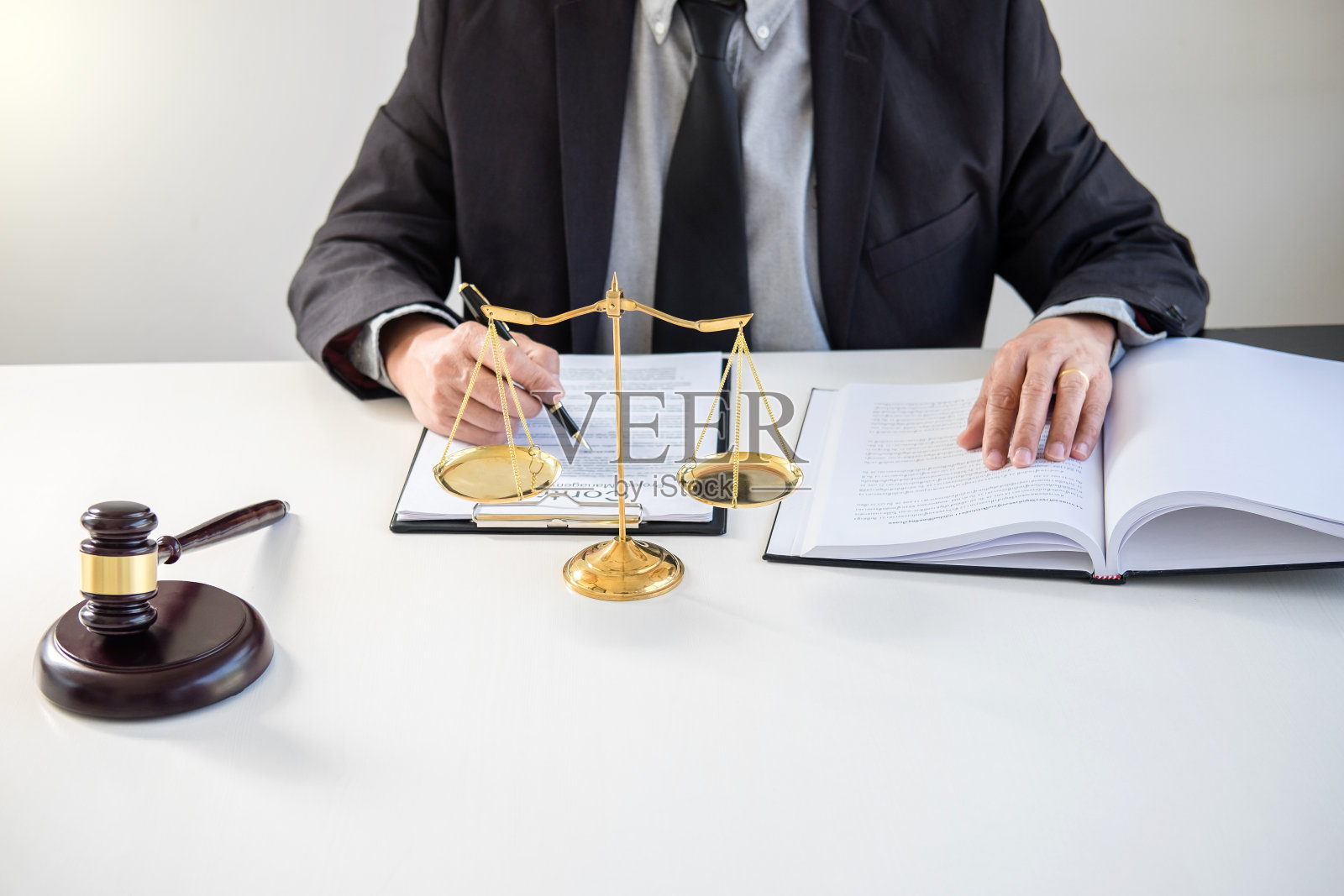 男性律师或法官在现代办公室查阅法律书籍和案件报告照片摄影图片