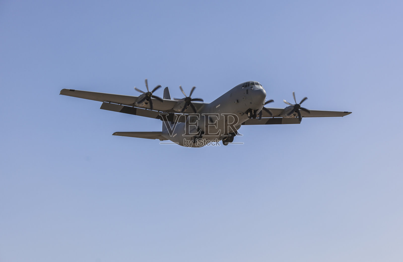 军事货运飞机洛克希德c - 130大力神在蓝天飞行照片摄影图片