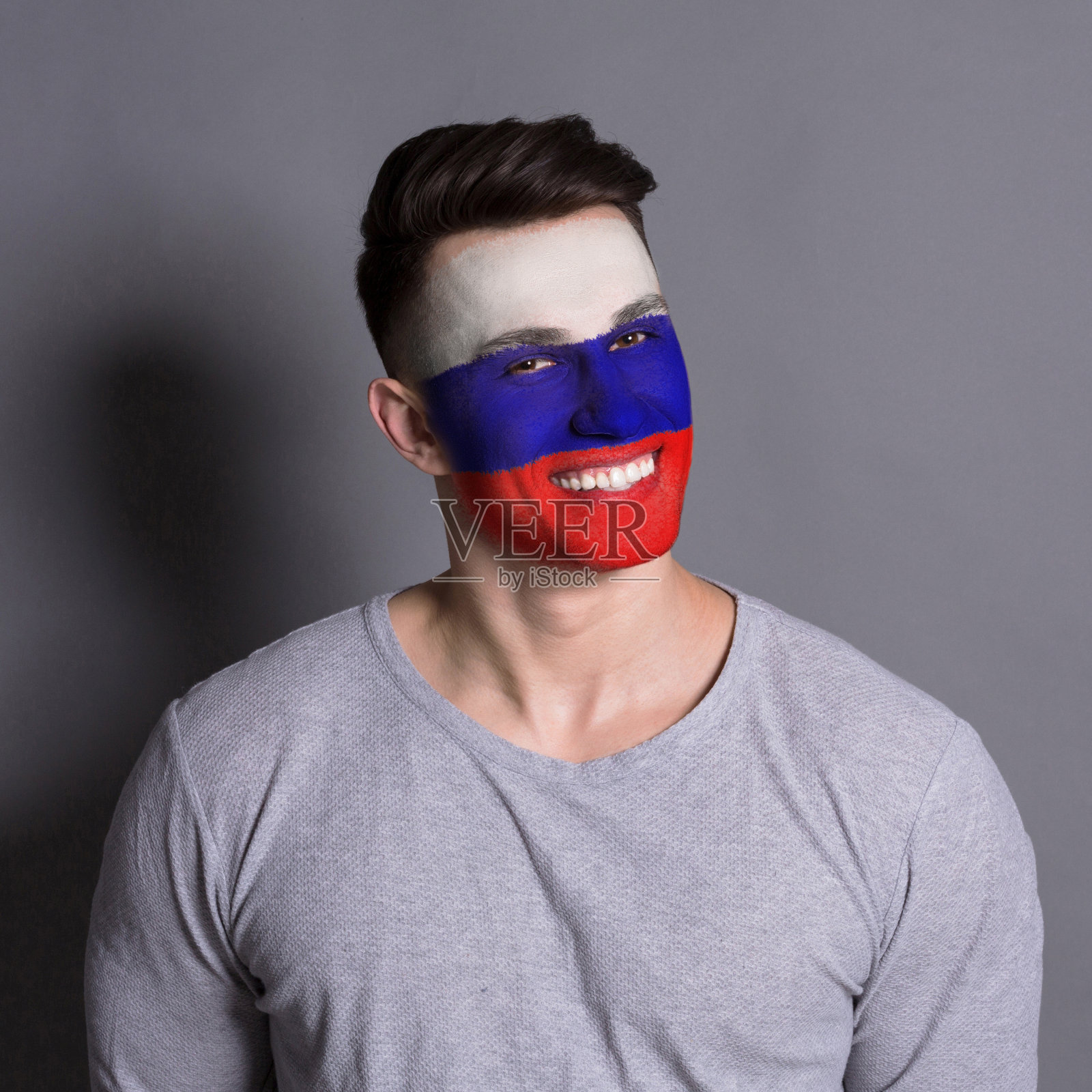 脸上画着俄罗斯国旗的年轻人照片摄影图片