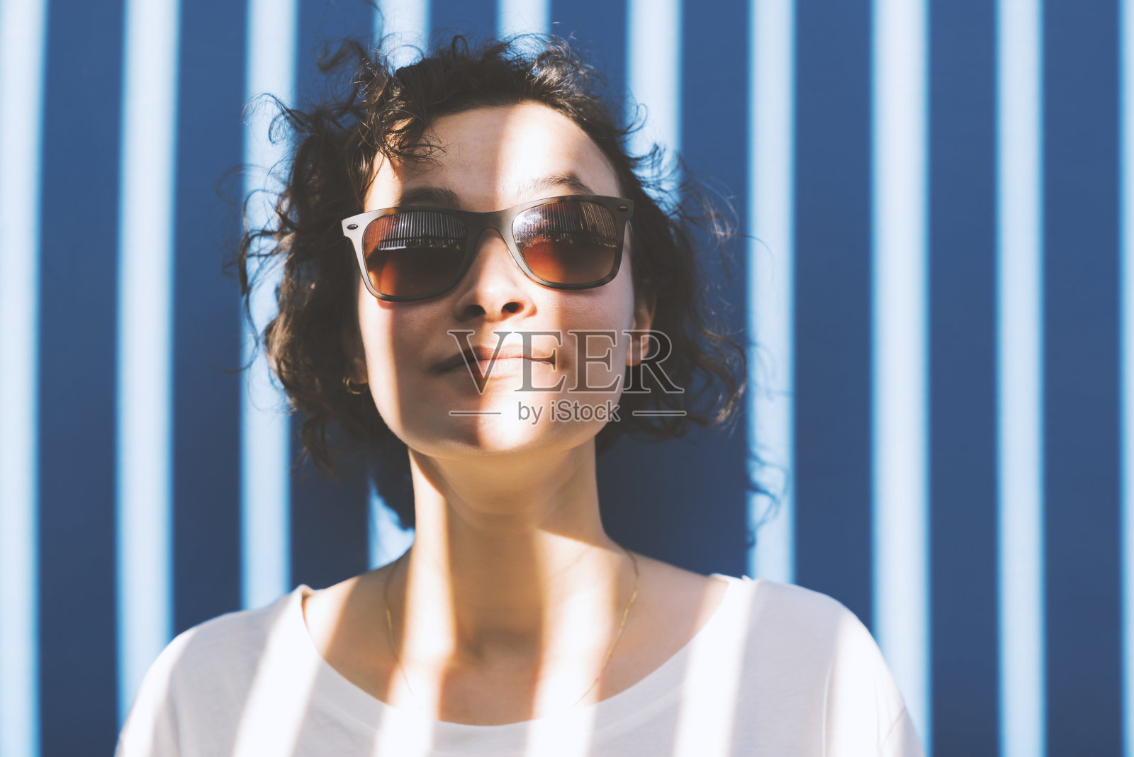 蓝色背景的年轻女子的肖像照片摄影图片