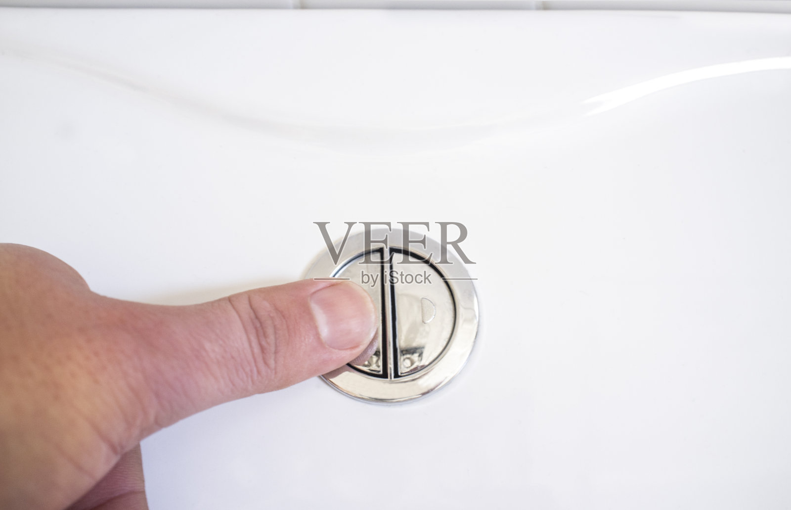 手指按马桶冲水按钮进行清洁。完全放电按钮照片摄影图片