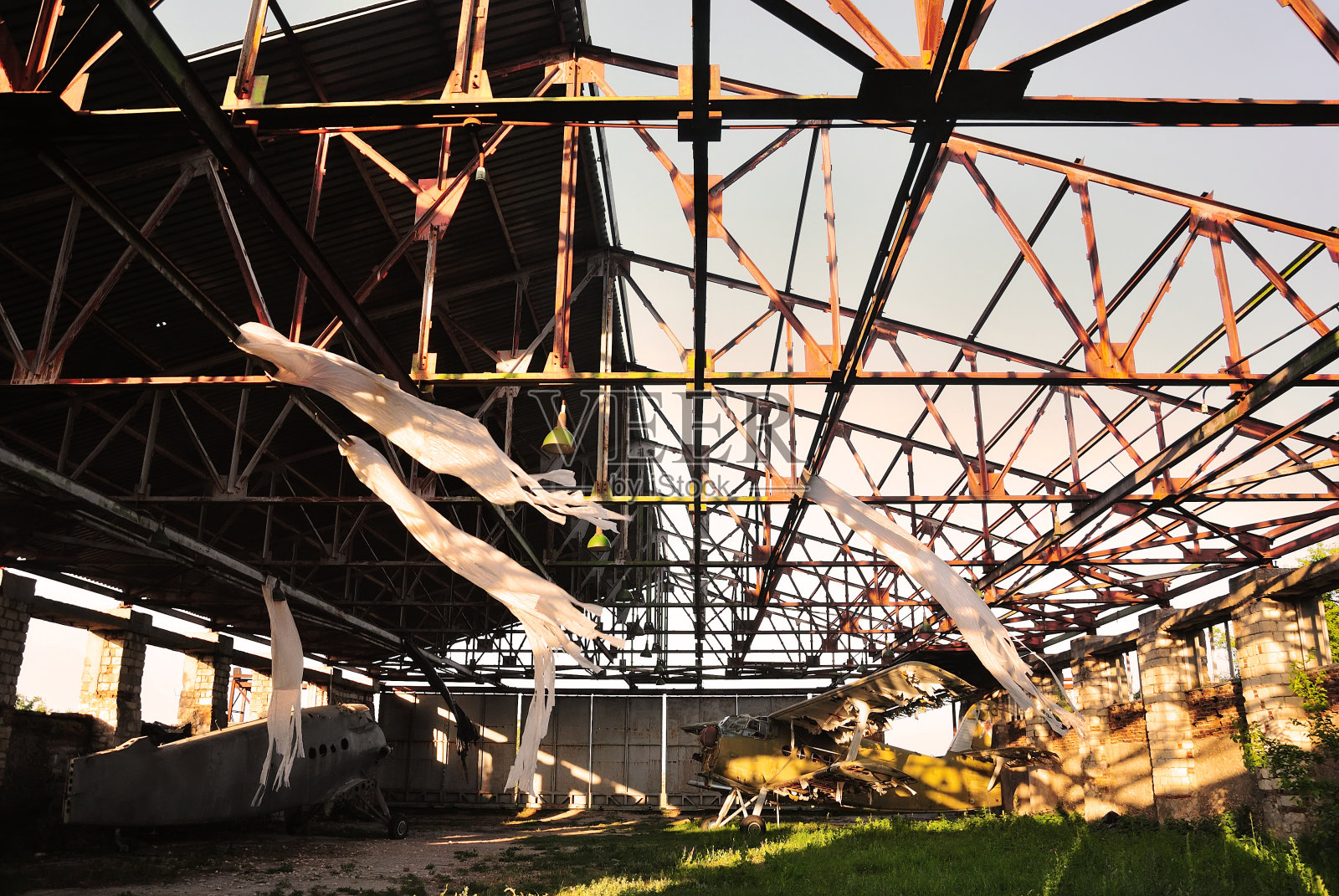 旧的复古飞机双翼飞机在一个废弃的被摧毁的机库照片摄影图片