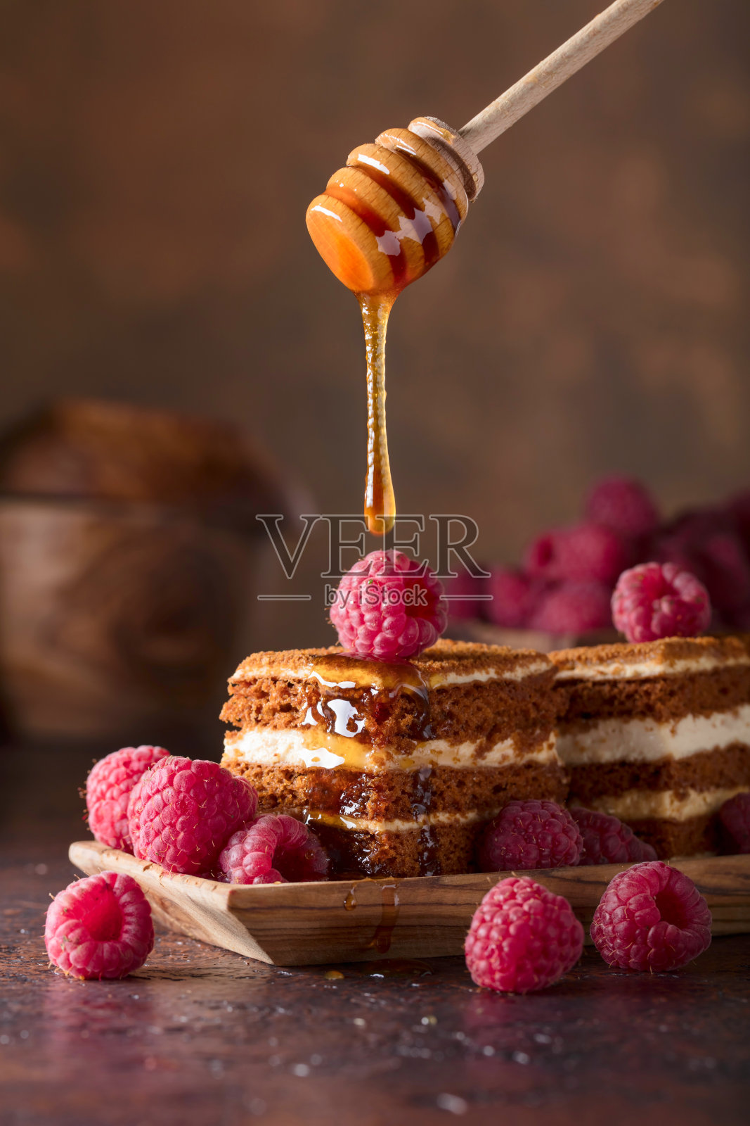 多层奶油和覆盆子蜂蜜蛋糕。照片摄影图片