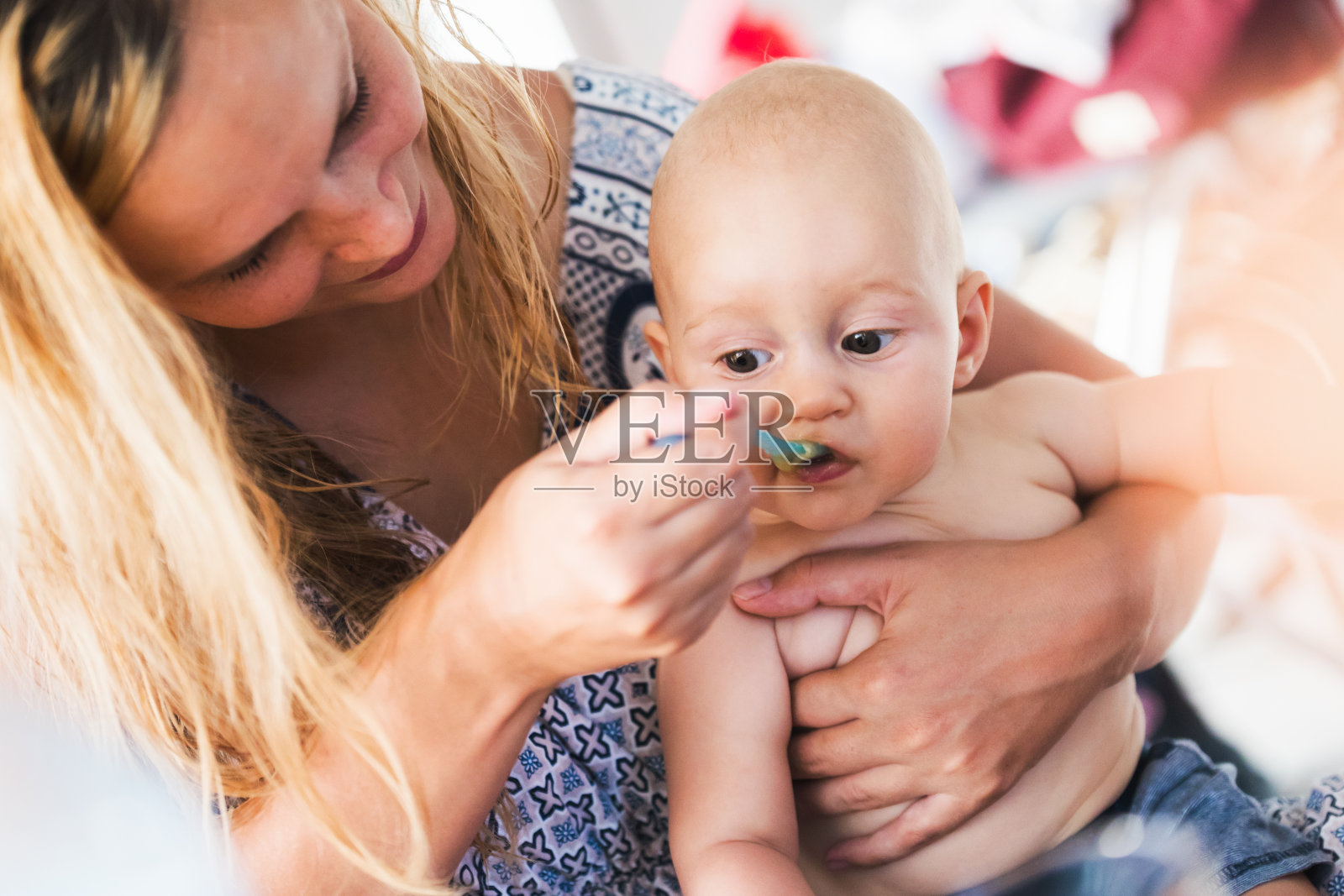 母亲用勺子喂婴儿的肖像照片摄影图片