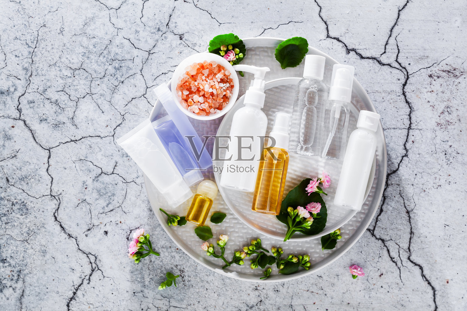 化妆品瓶容器与绿色草药叶子，空白标签的品牌模型，自然美容产品的概念。照片摄影图片