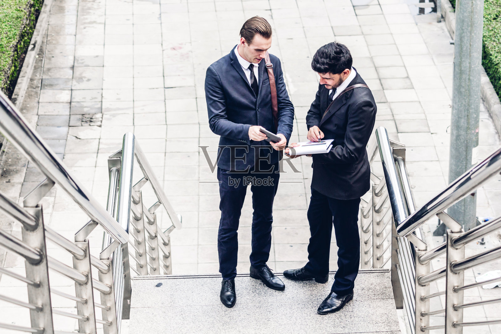 两个微笑的商人在城市中交谈和行走照片摄影图片