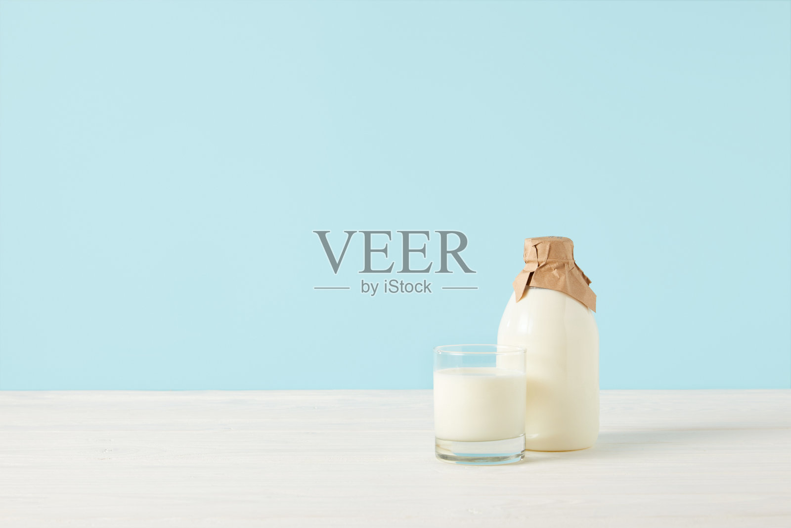 牛奶玻璃和牛奶在瓶子包装的纸在蓝色的背景照片摄影图片