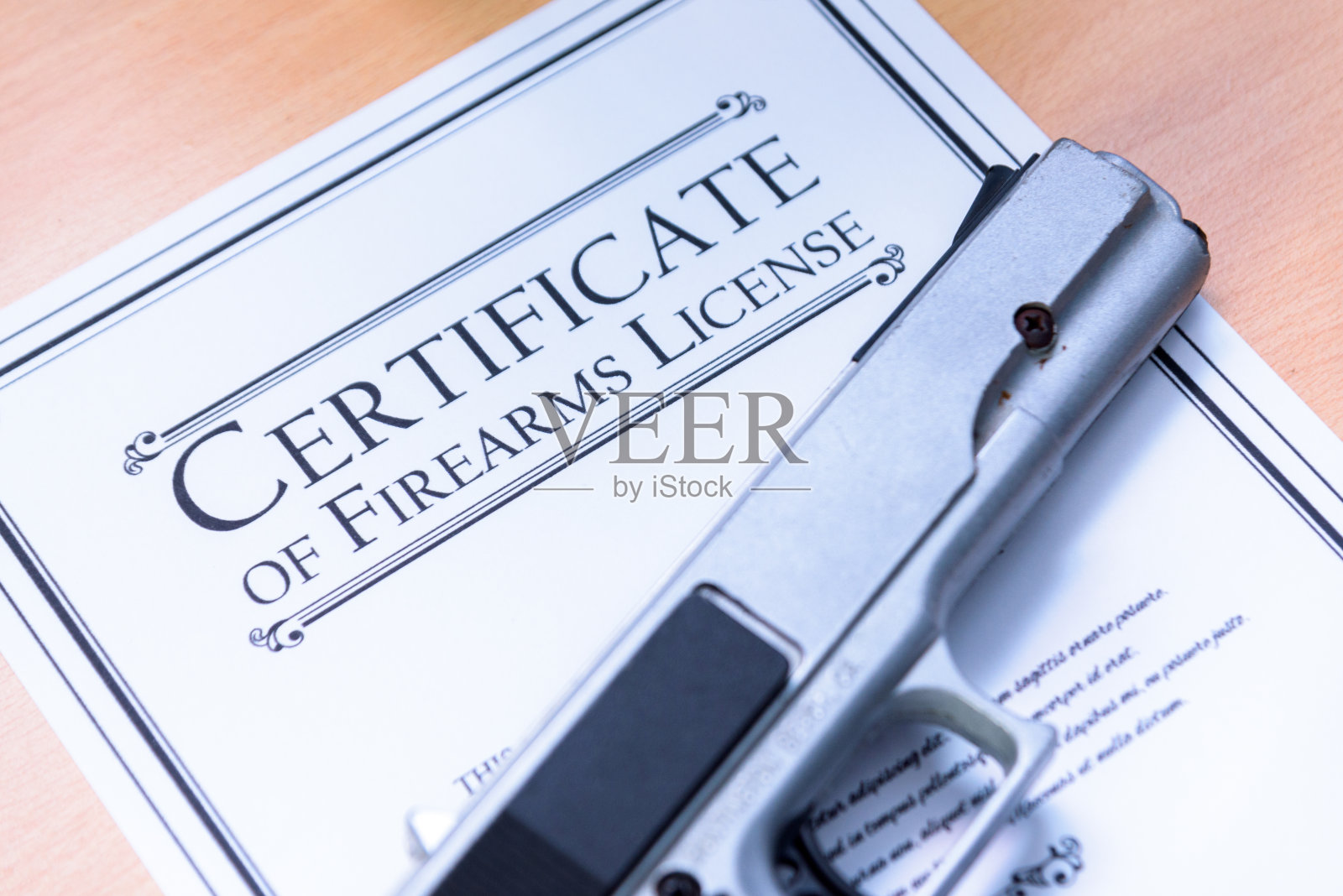 手枪放置在枪支/枪支许可证证书上照片摄影图片