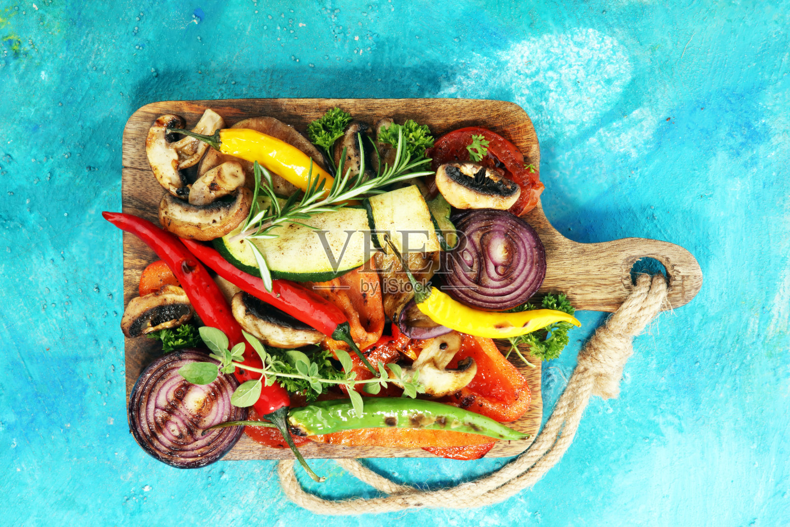 烤蔬菜。西红柿，西葫芦，甜椒和新鲜香草。照片摄影图片