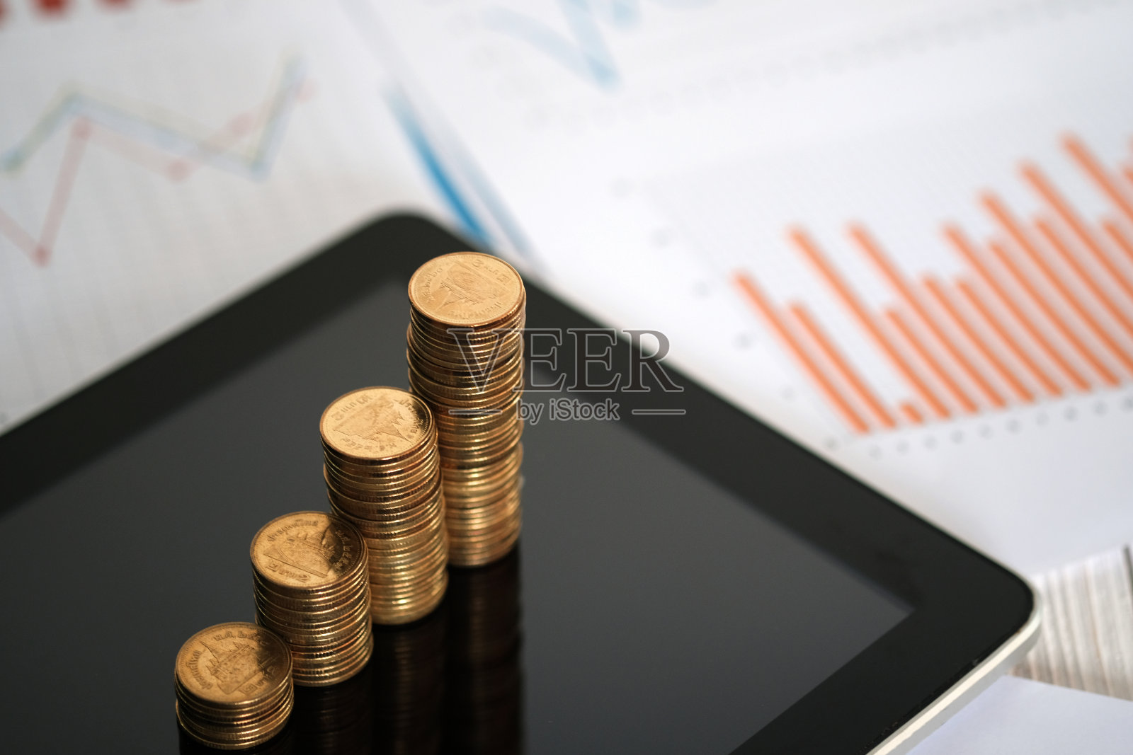 步骤硬币堆栈和平板电脑与财务图表，业务规划愿景和财务分析的概念。照片摄影图片