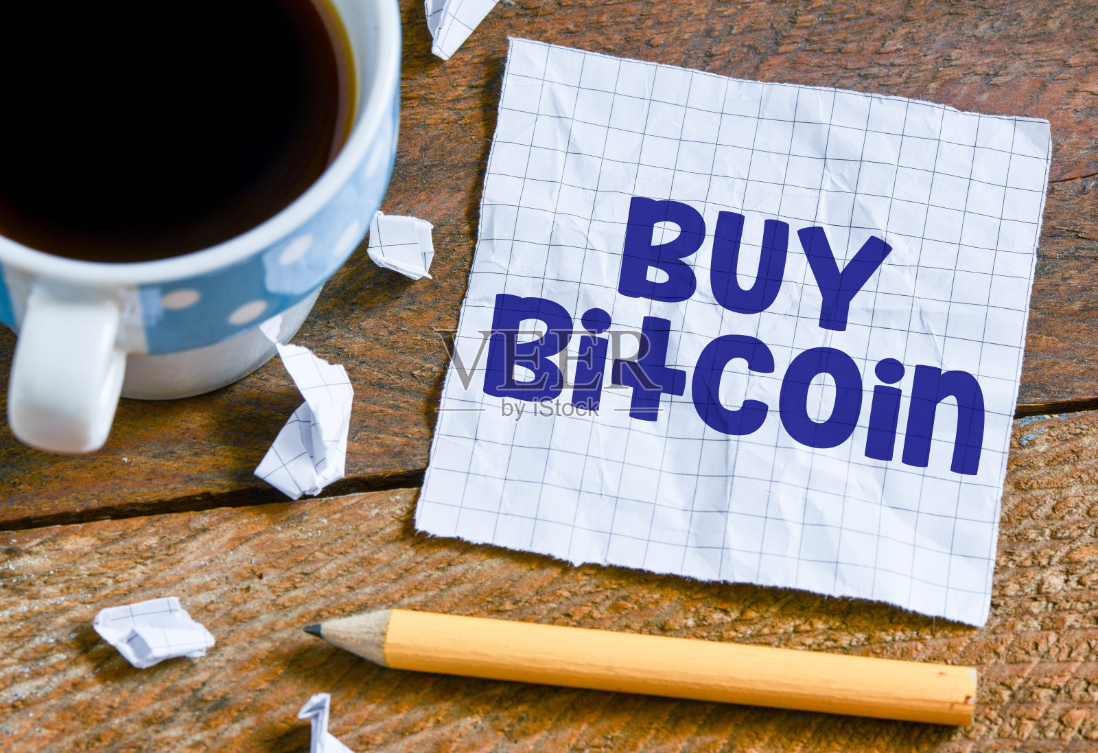 在笔记本上购买比特币文本与钢笔和咖啡杯在木制的背景照片摄影图片