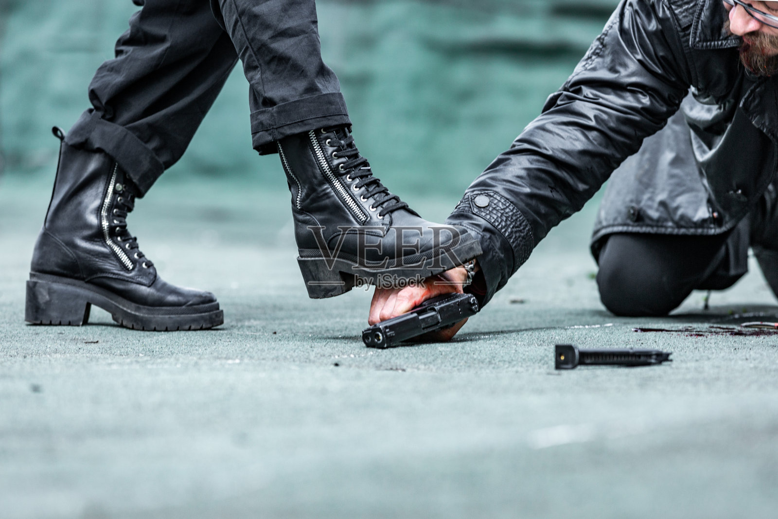 血淋淋的男人，他伸手去拿枪，一个女人的腿伸向了他的手照片摄影图片