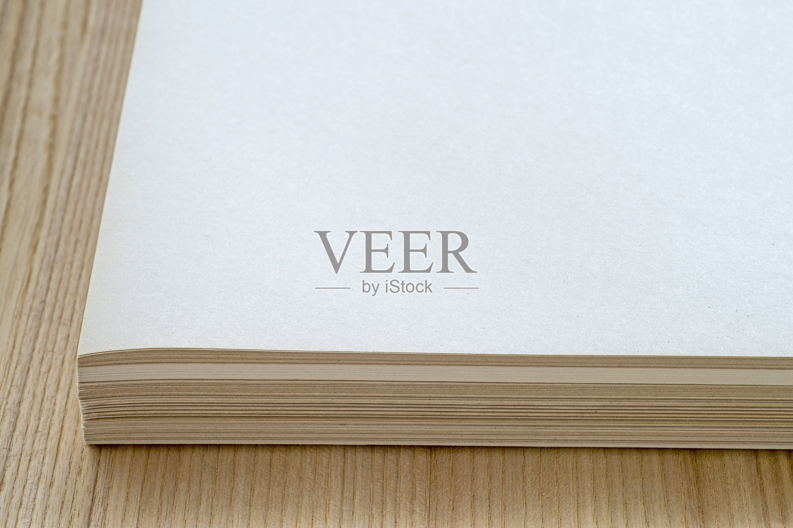 一叠干净的纸张，带有木纹的桌面背景照片摄影图片