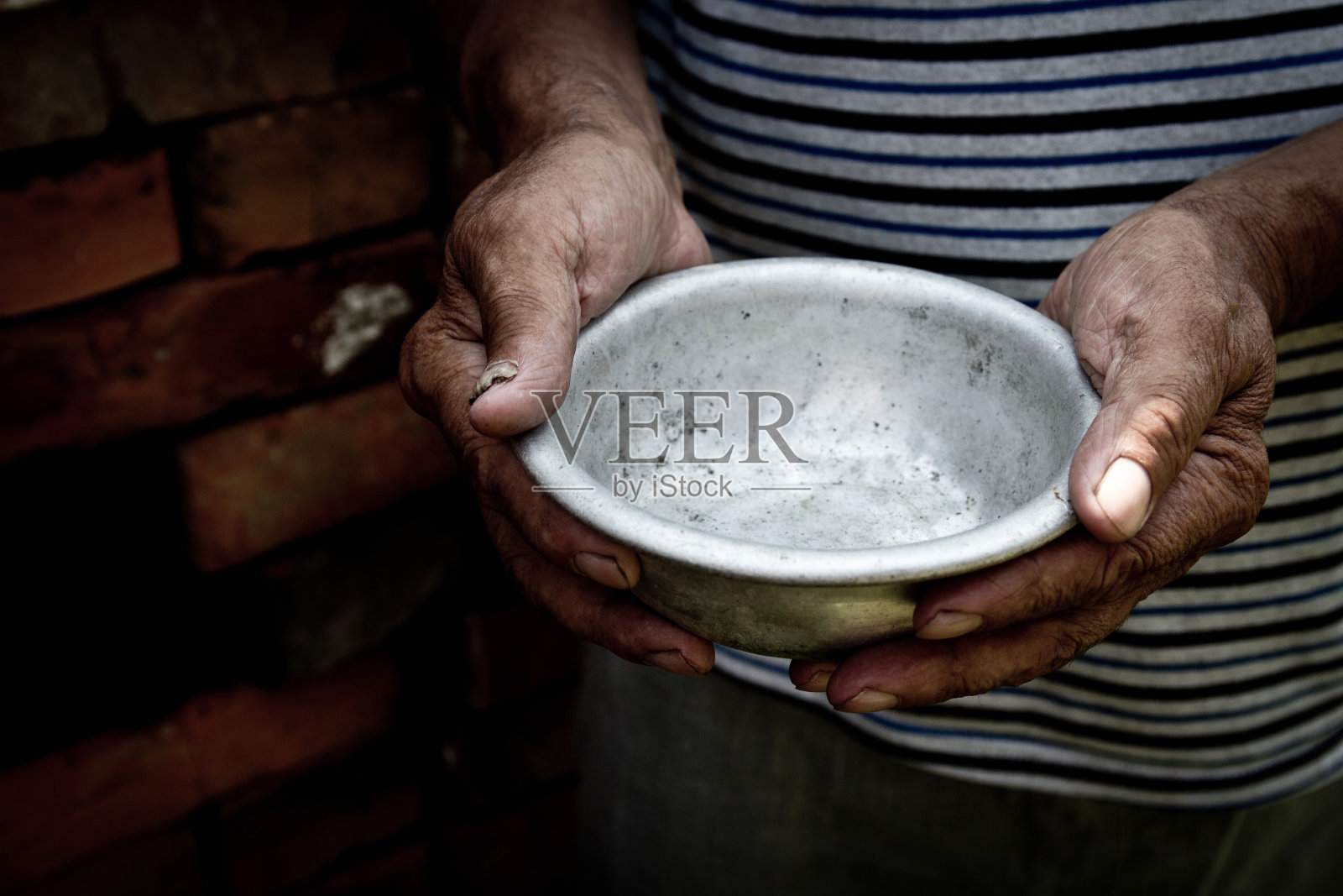 这个可怜的老人的手拿着一个空碗。饥饿或贫穷的概念。有选择性的重点。在retirement.Homeless贫困。施舍照片摄影图片