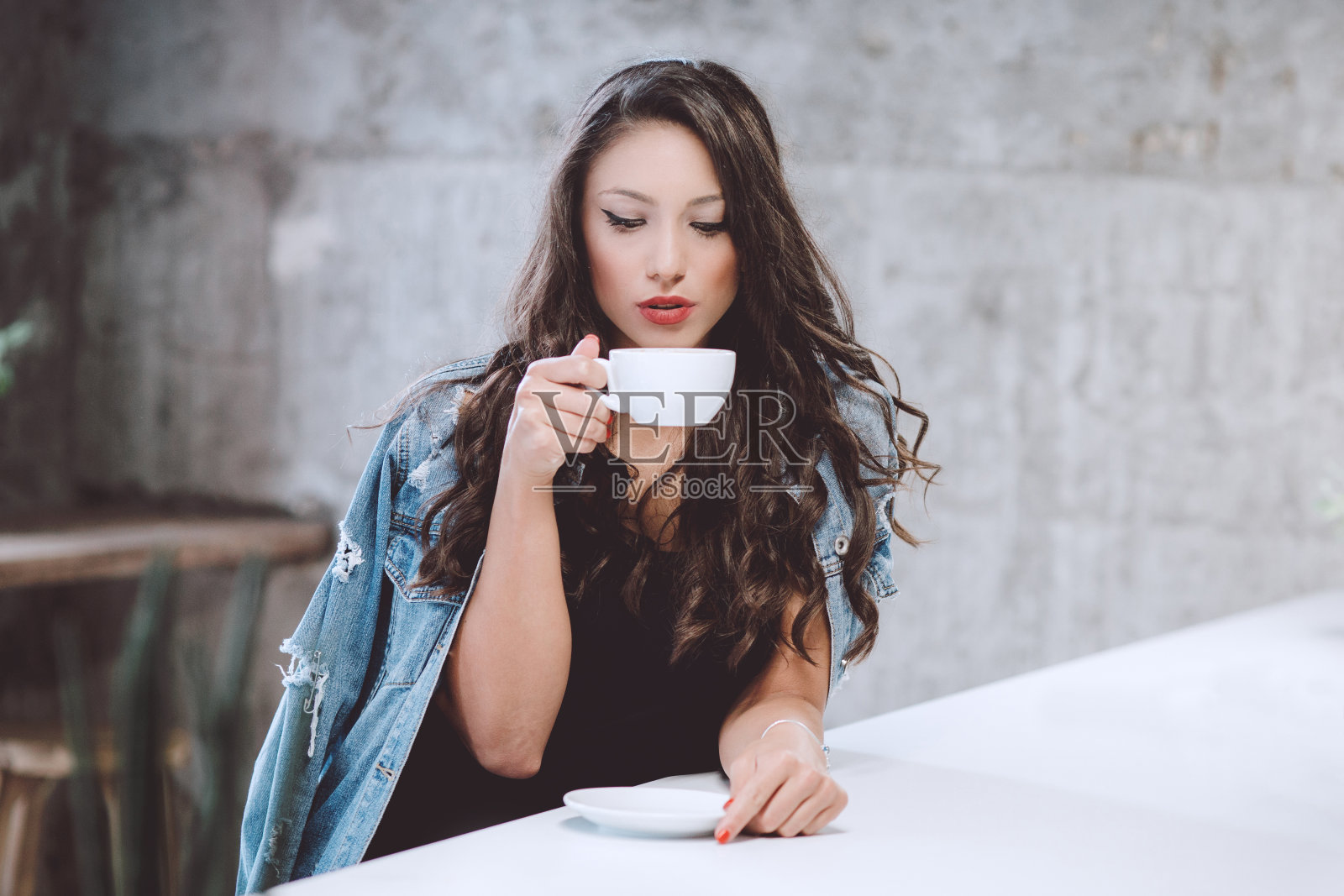 在咖啡馆喝咖啡的女人。照片摄影图片