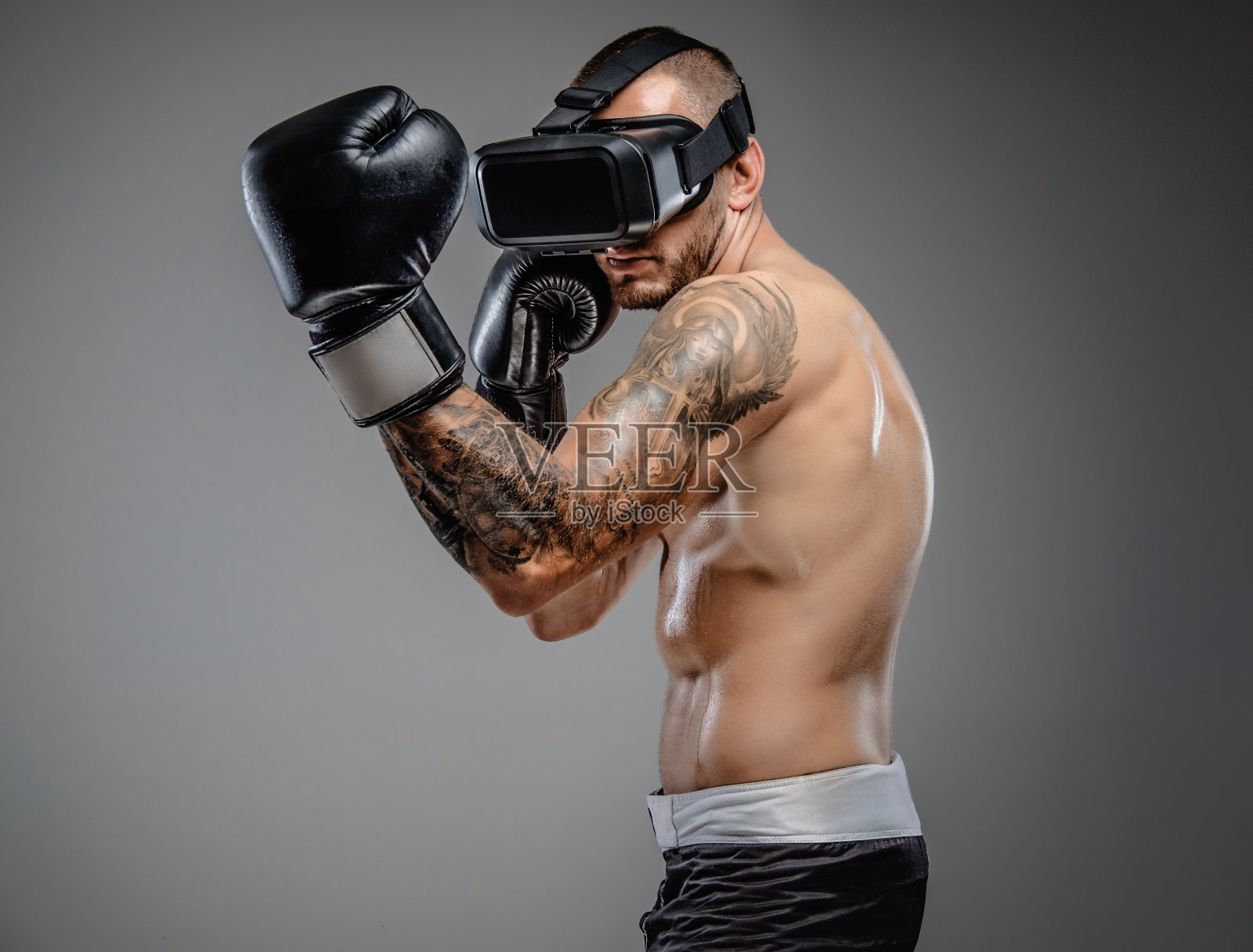 赤裸上身戴着虚拟现实眼镜的野蛮拳手。照片摄影图片