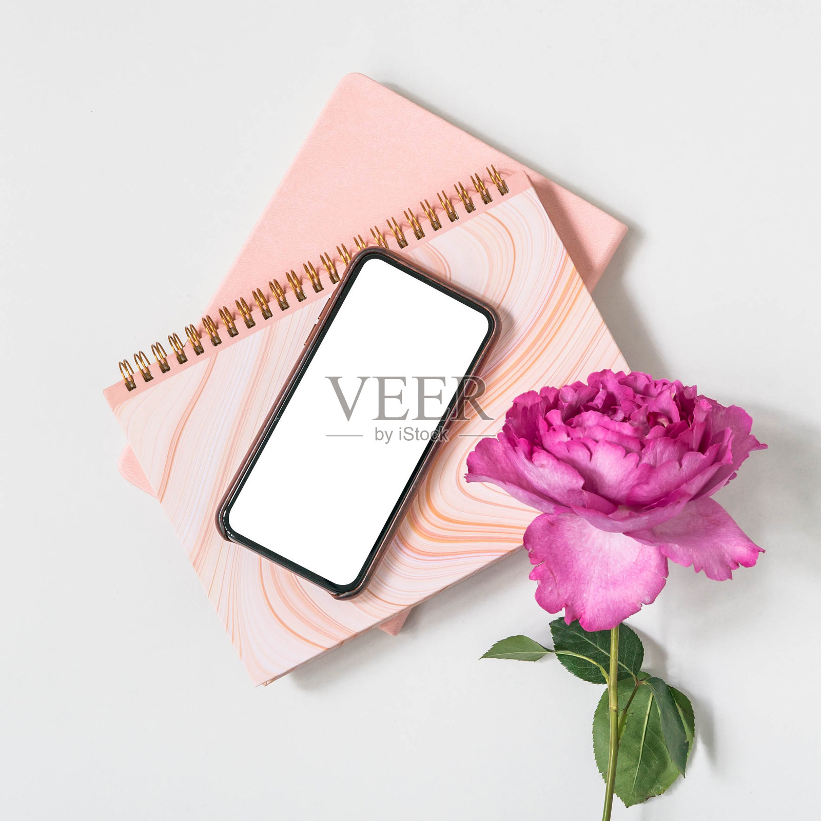 粉色玫瑰的智能手机。照片摄影图片