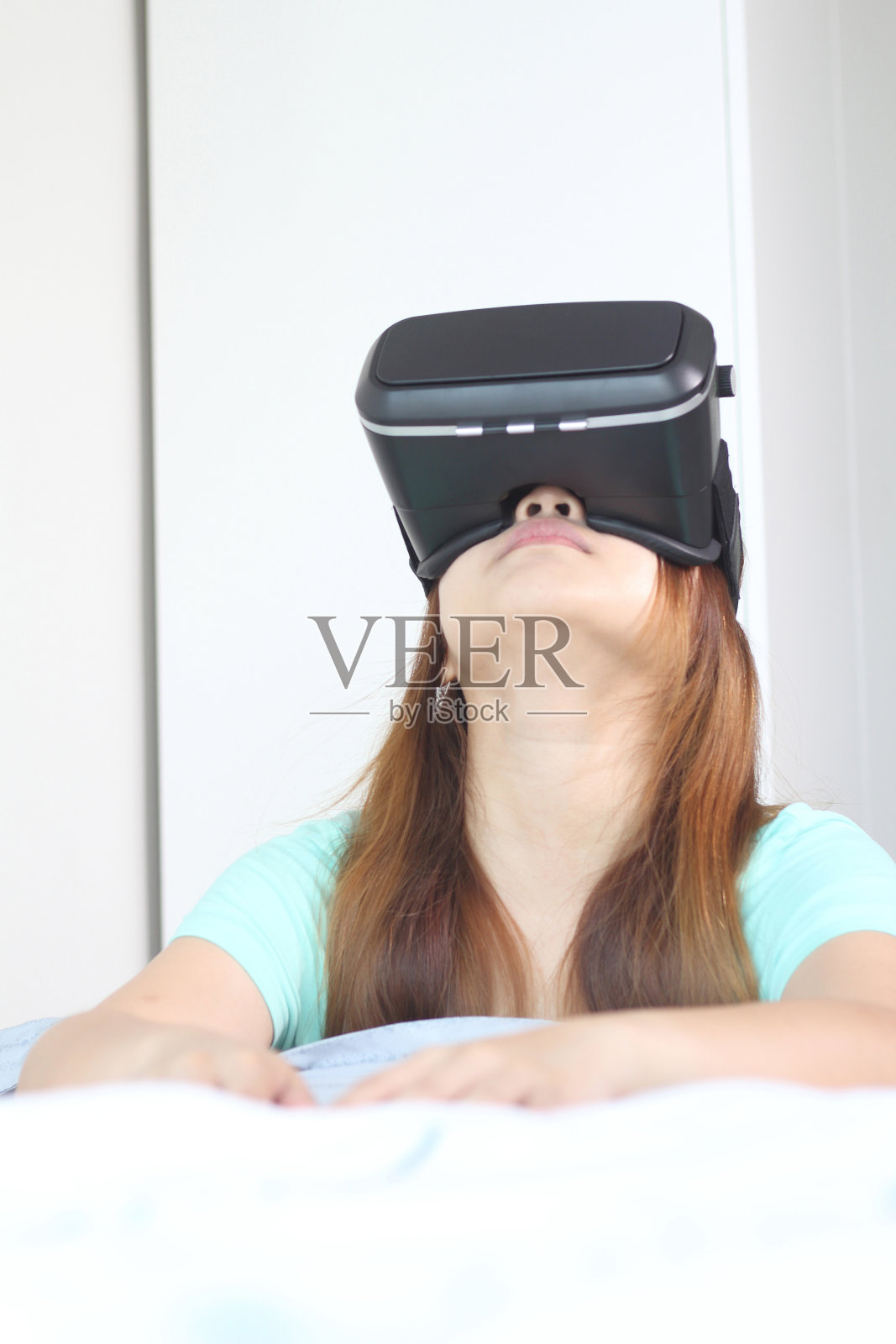 年轻女子在家里戴着虚拟现实眼镜。照片摄影图片