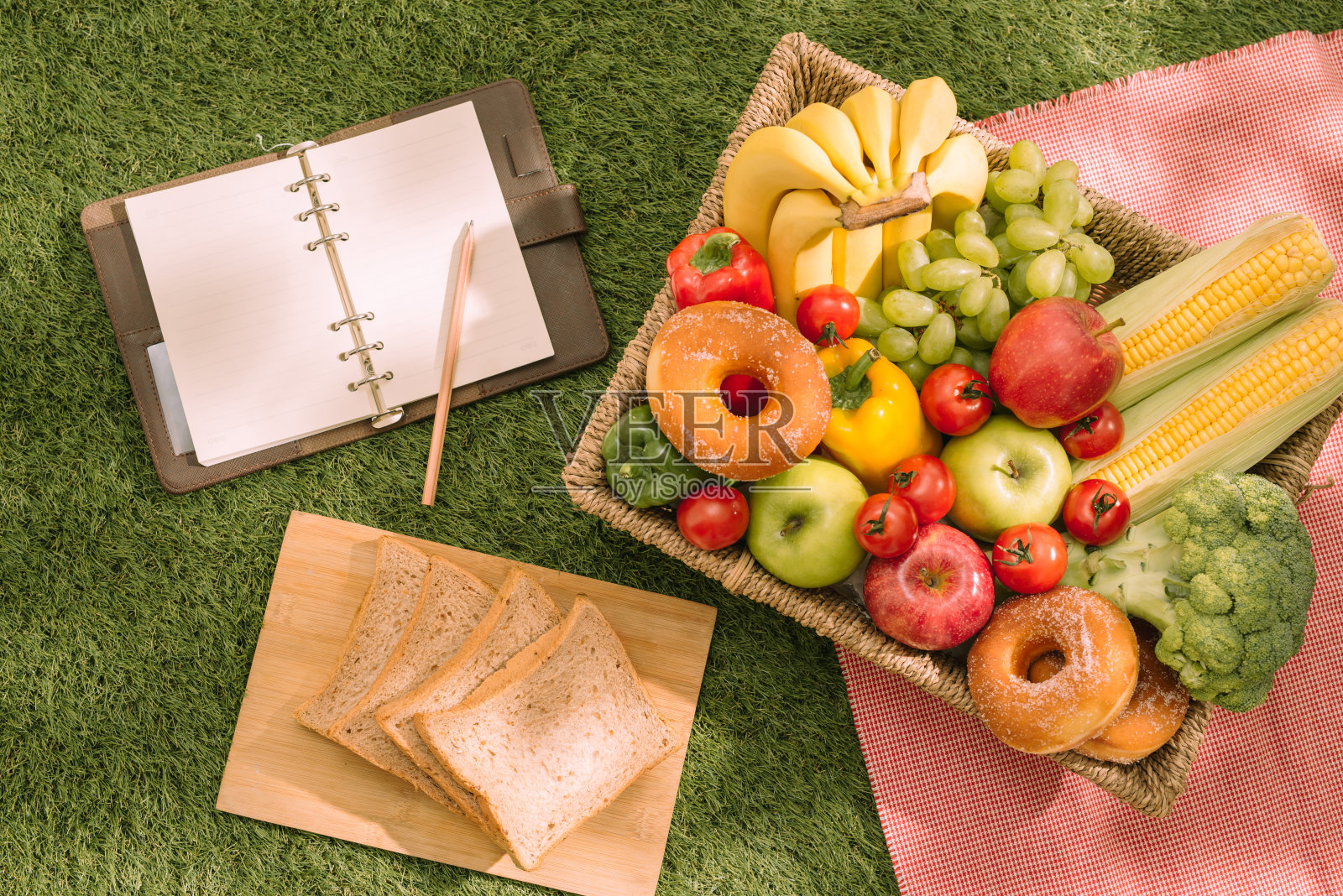 夏季野餐设置在草地上开放的野餐篮子，水果，沙拉和樱桃派照片摄影图片