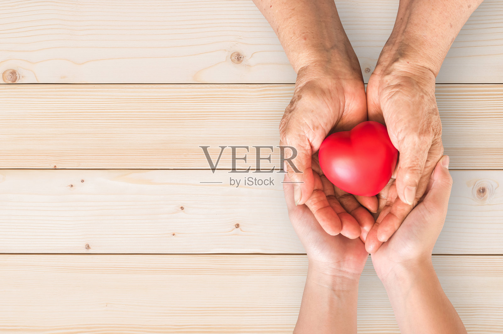 老年人或祖父母的手用红心支持护理家庭看护者为国家临终关怀姑息护理和家庭看护者月的概念照片摄影图片