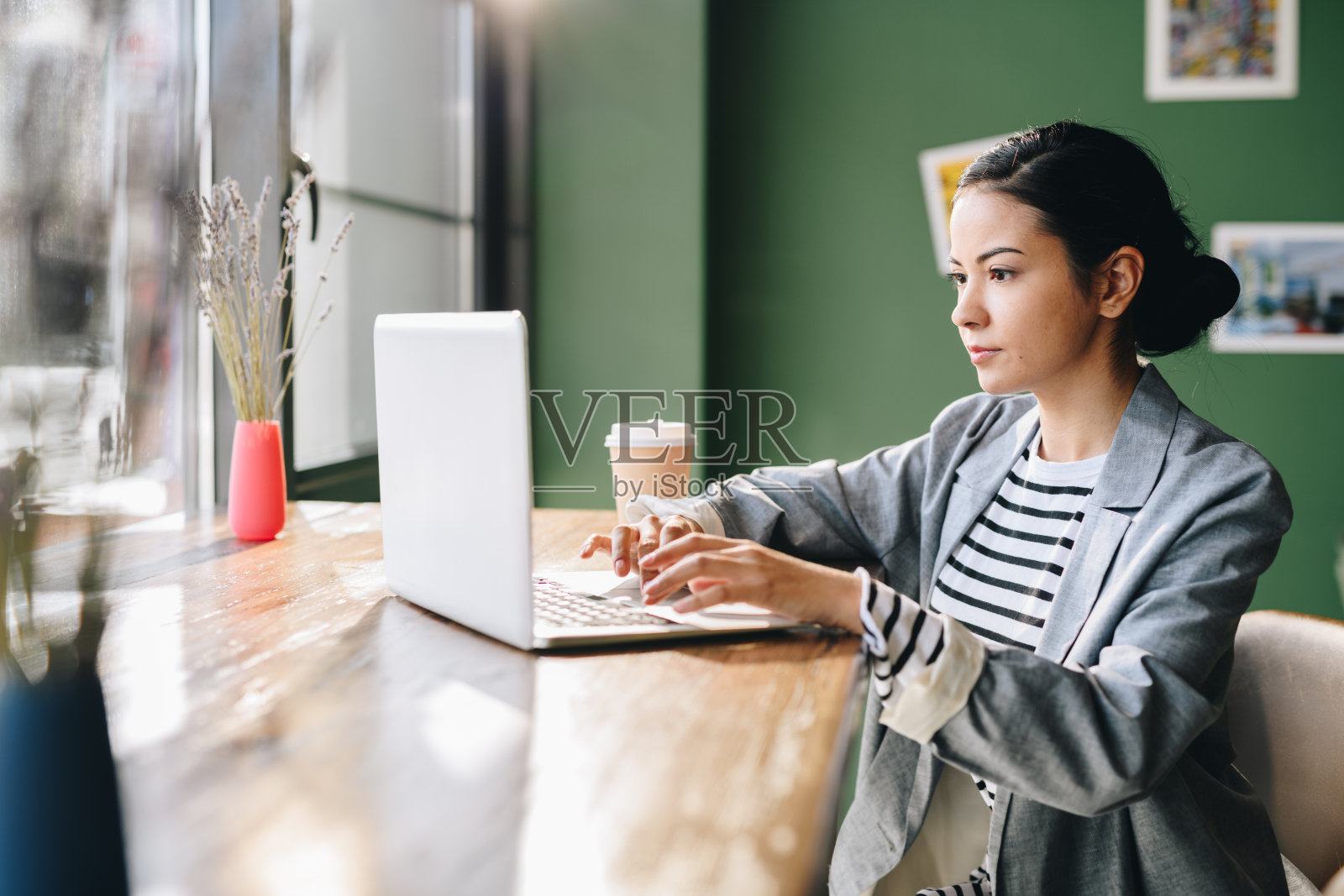 认真忙碌的年轻混血女士在笔记本电脑上打字，同时处理在线数据和使用咖啡馆的wi-fi照片摄影图片