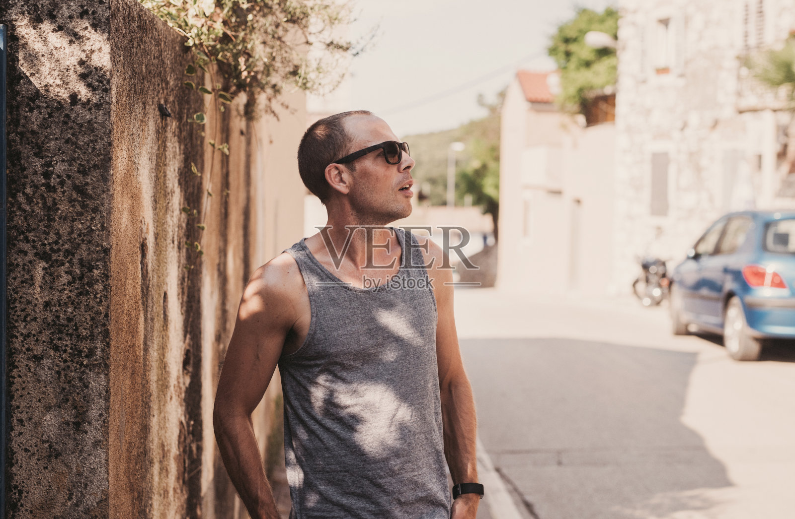 阳光明媚的夏日里，穿着背心和太阳镜的男人在户外照片摄影图片