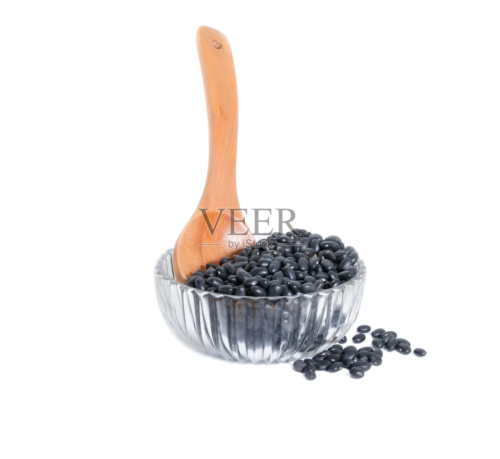白色背景下玻璃碗里的黑豆和木勺照片摄影图片