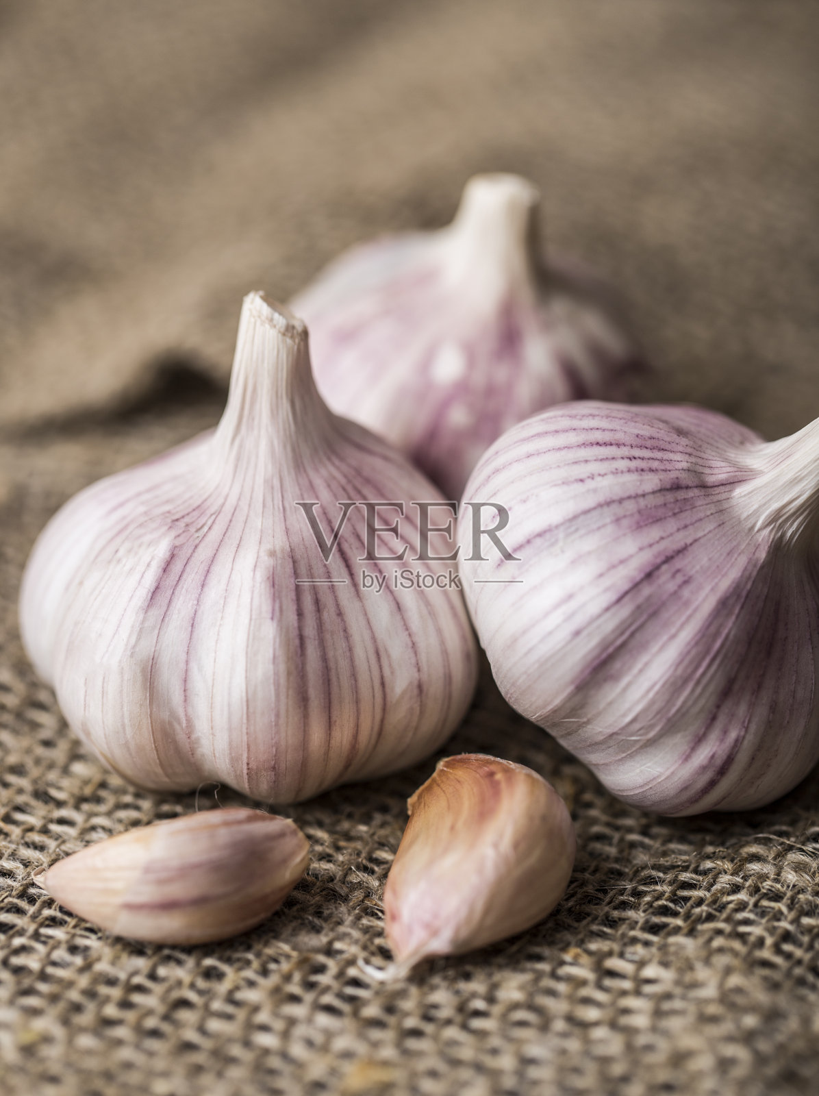 木质背景上的新鲜大蒜。大蒜鳞茎照片摄影图片
