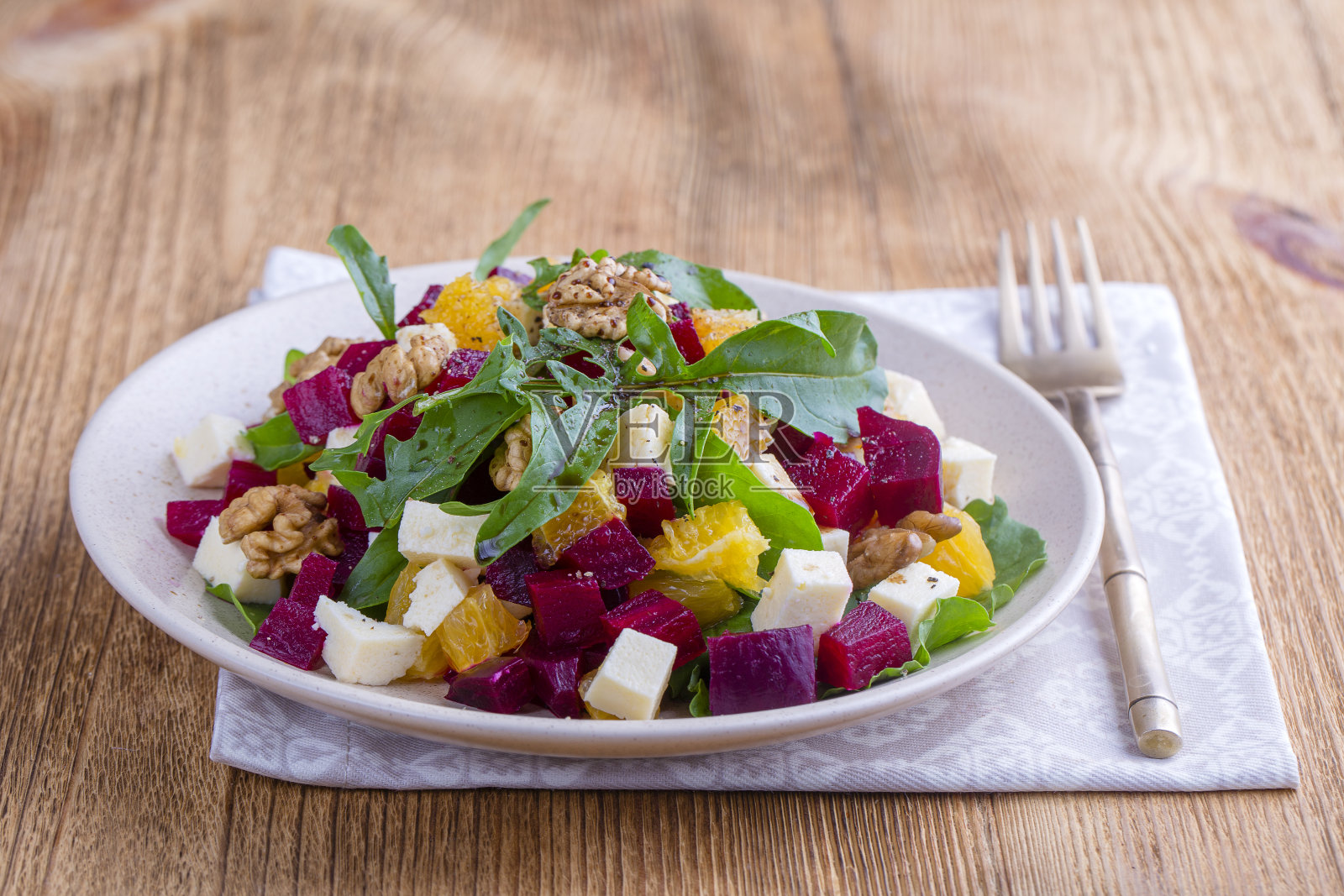 健康素食沙拉：甜菜根、绿色芝麻菜、橙子、菲达奶酪和核桃照片摄影图片
