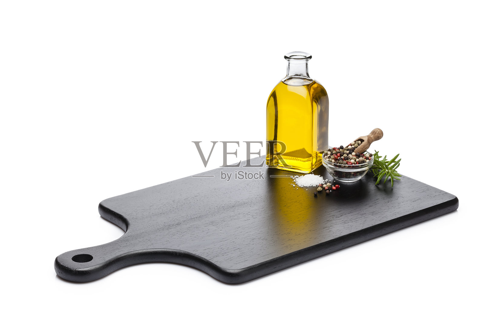 将橄榄油、盐和胡椒粉放在一块黑色的砧板上，孤立地放在白色的背景上照片摄影图片