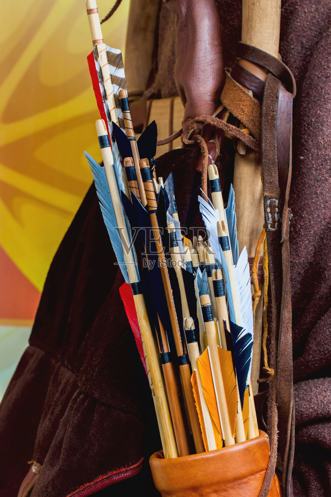 历史的一套古老的木制箭与明亮的羽毛在箭筒的特写照片摄影图片