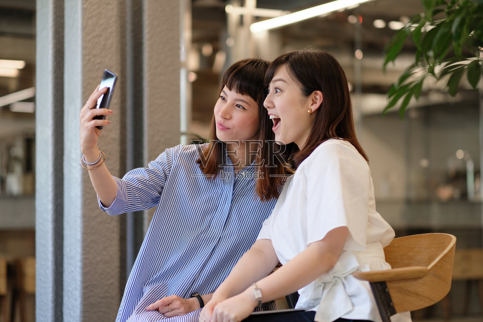 两个女人，国际友人，正在咖啡馆自拍照片摄影图片