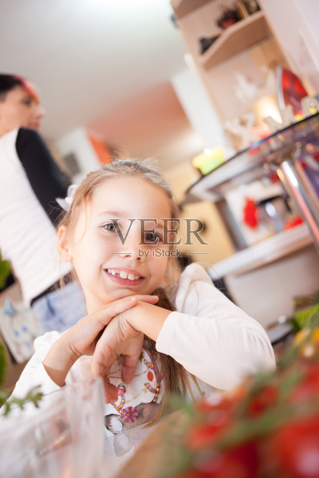 年轻快乐的女孩坐在屋里的桌子旁照片摄影图片