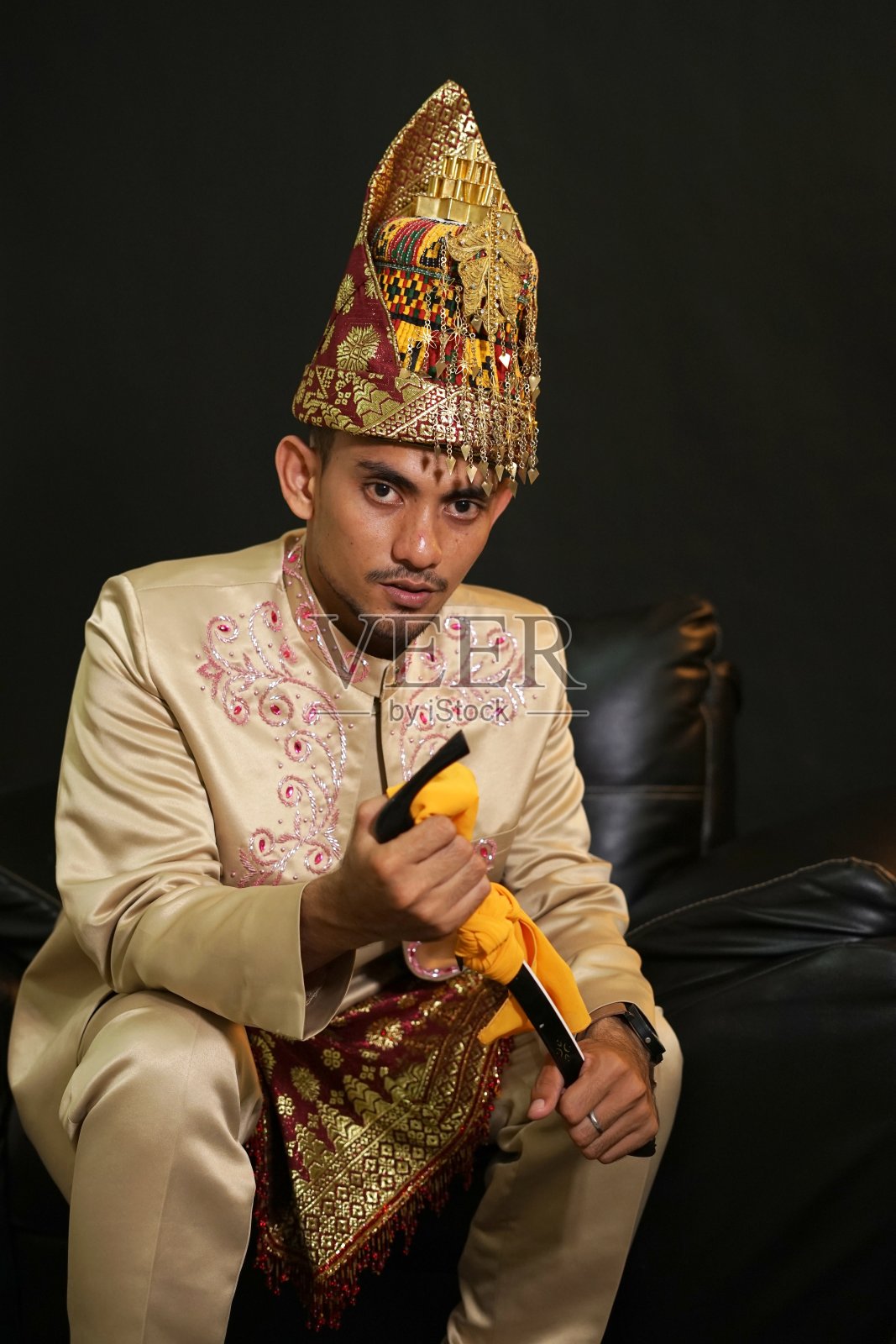 身着亚齐传统服饰的英俊男子手持仁琮(亚齐传统武器)照片摄影图片