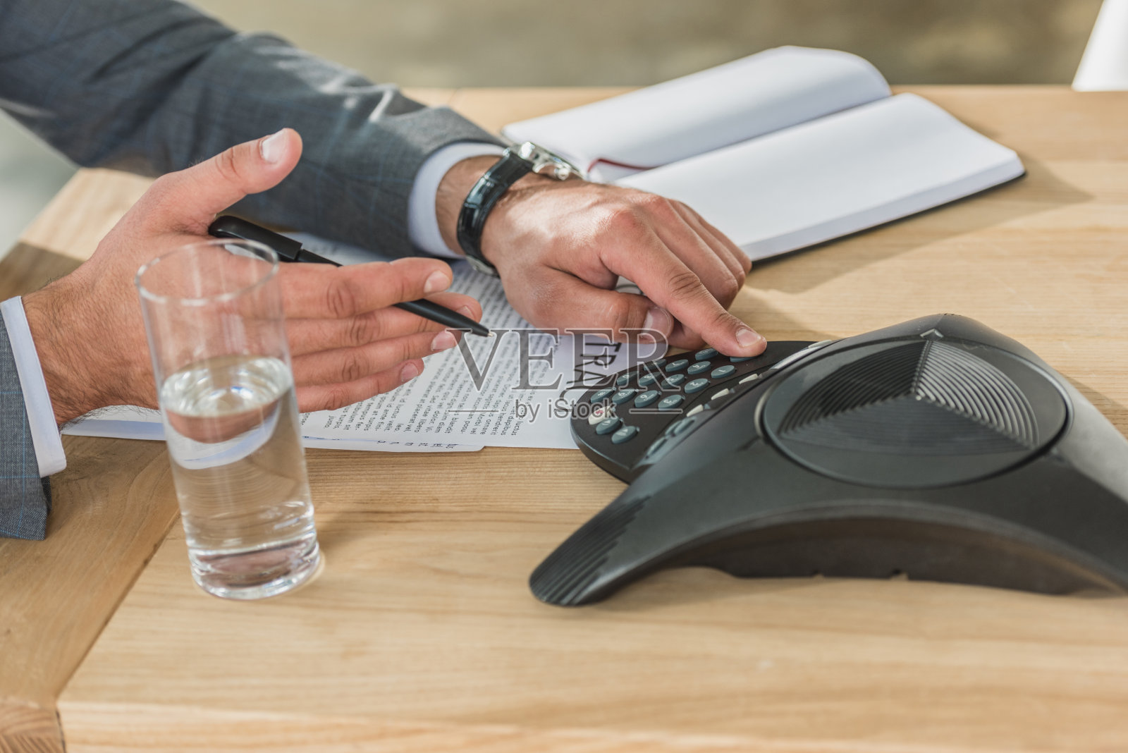 商人在办公室桌子上使用会议电话的镜头照片摄影图片