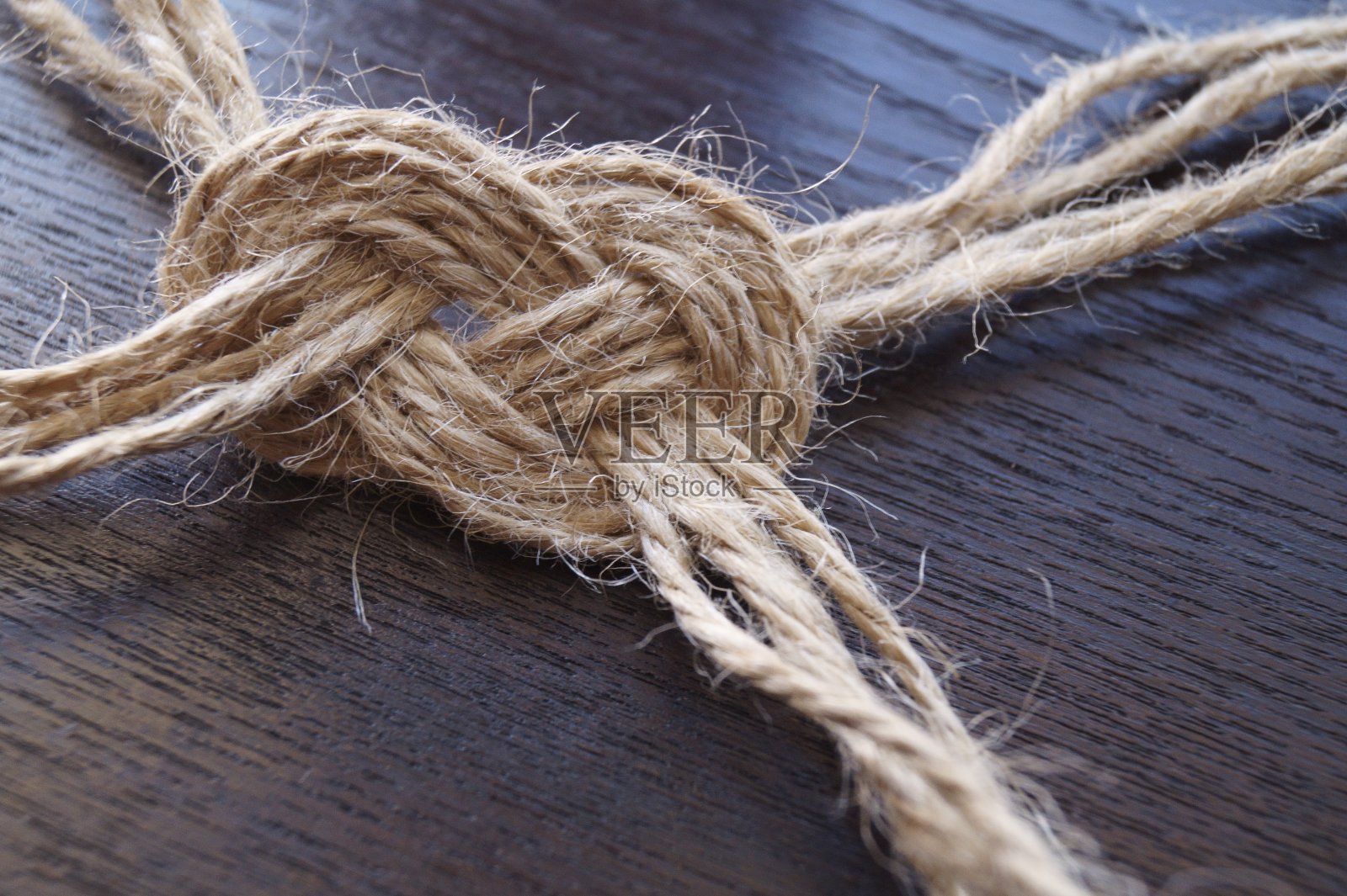 从黄麻麻绳结在木制的背景照片摄影图片