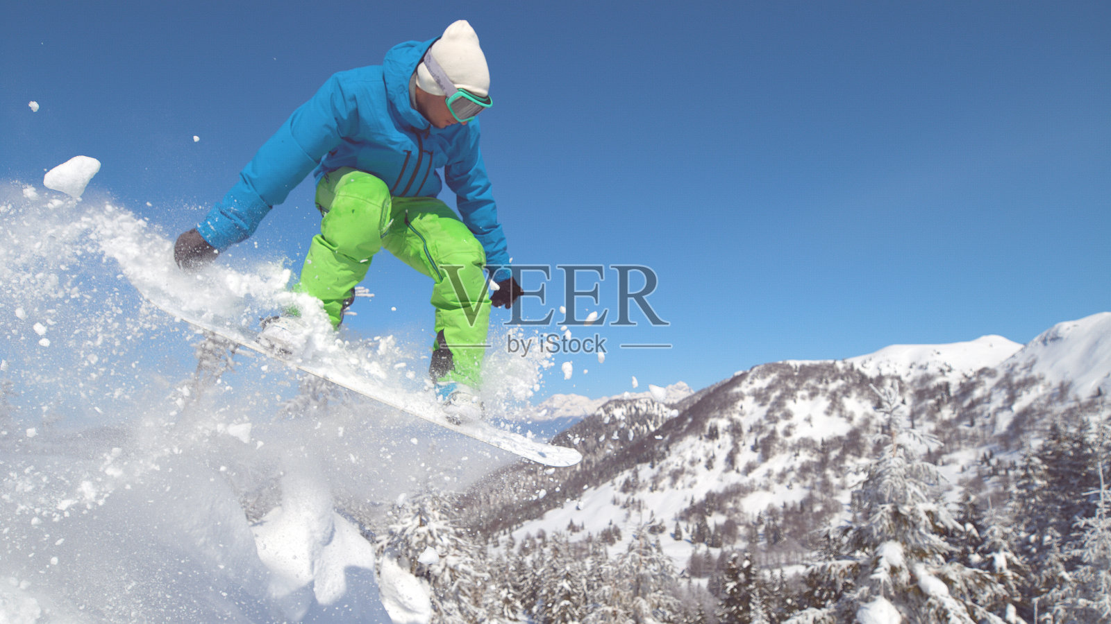 特写:专业滑雪板骑下坡和跳高的空中。照片摄影图片