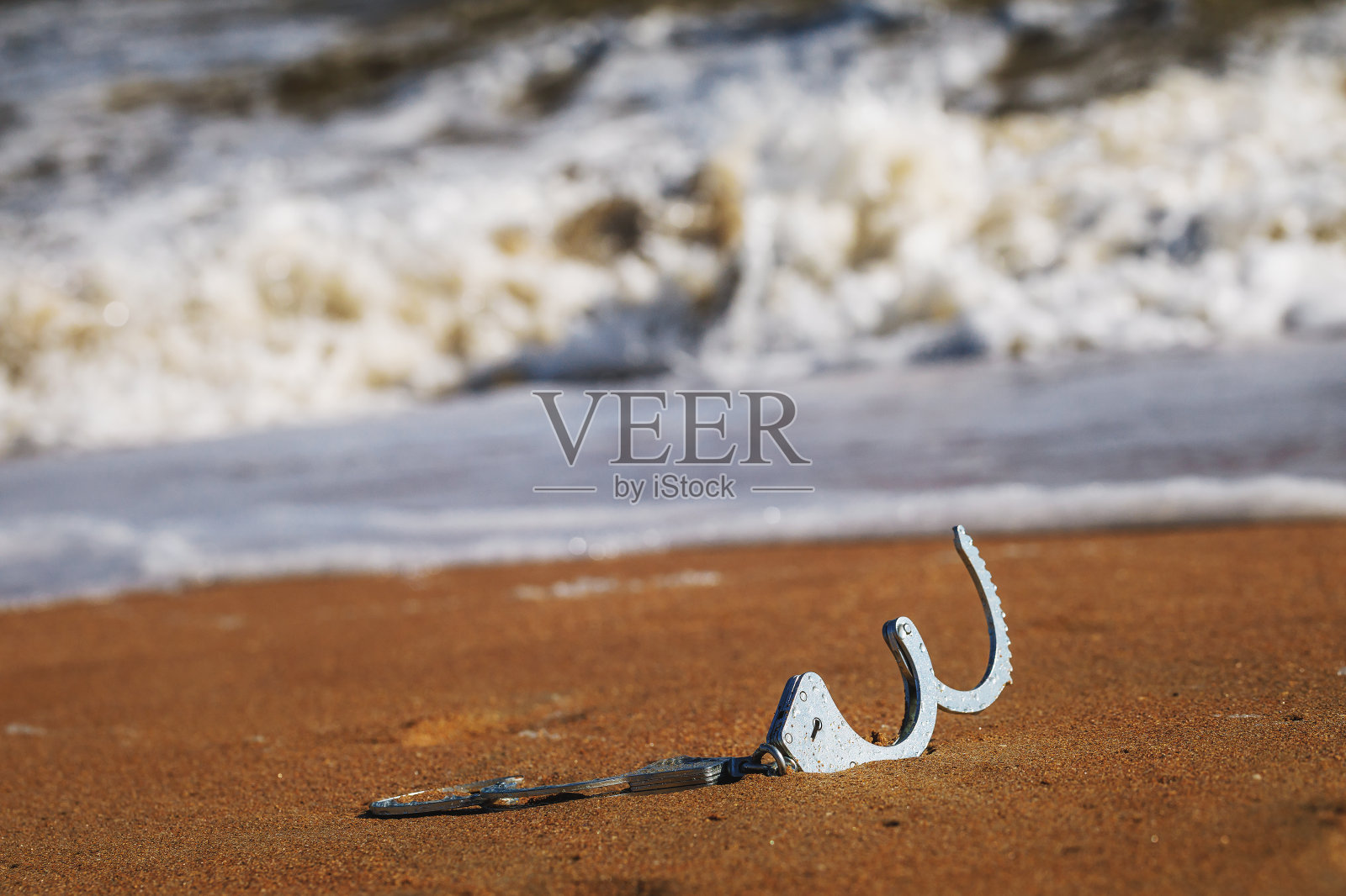 自由的概念:在海边的沙滩上解开的手铐照片摄影图片