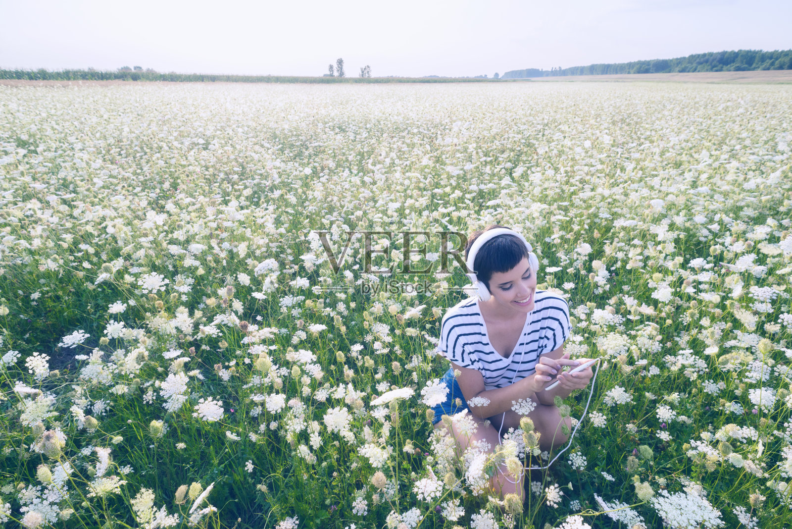在夏日的大自然中听音乐的女人照片摄影图片
