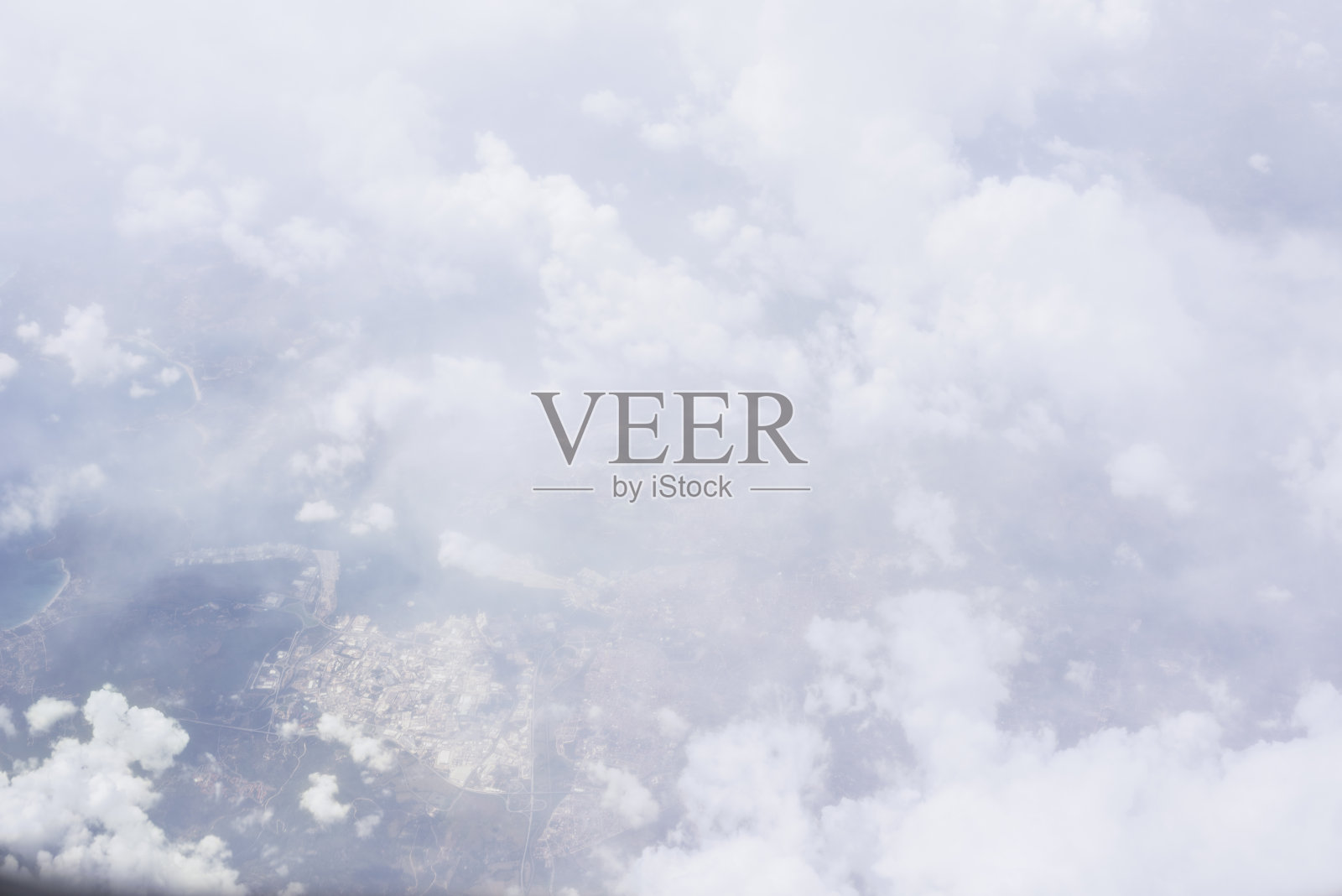 从飞机上看到的穿过云层的地形照片摄影图片