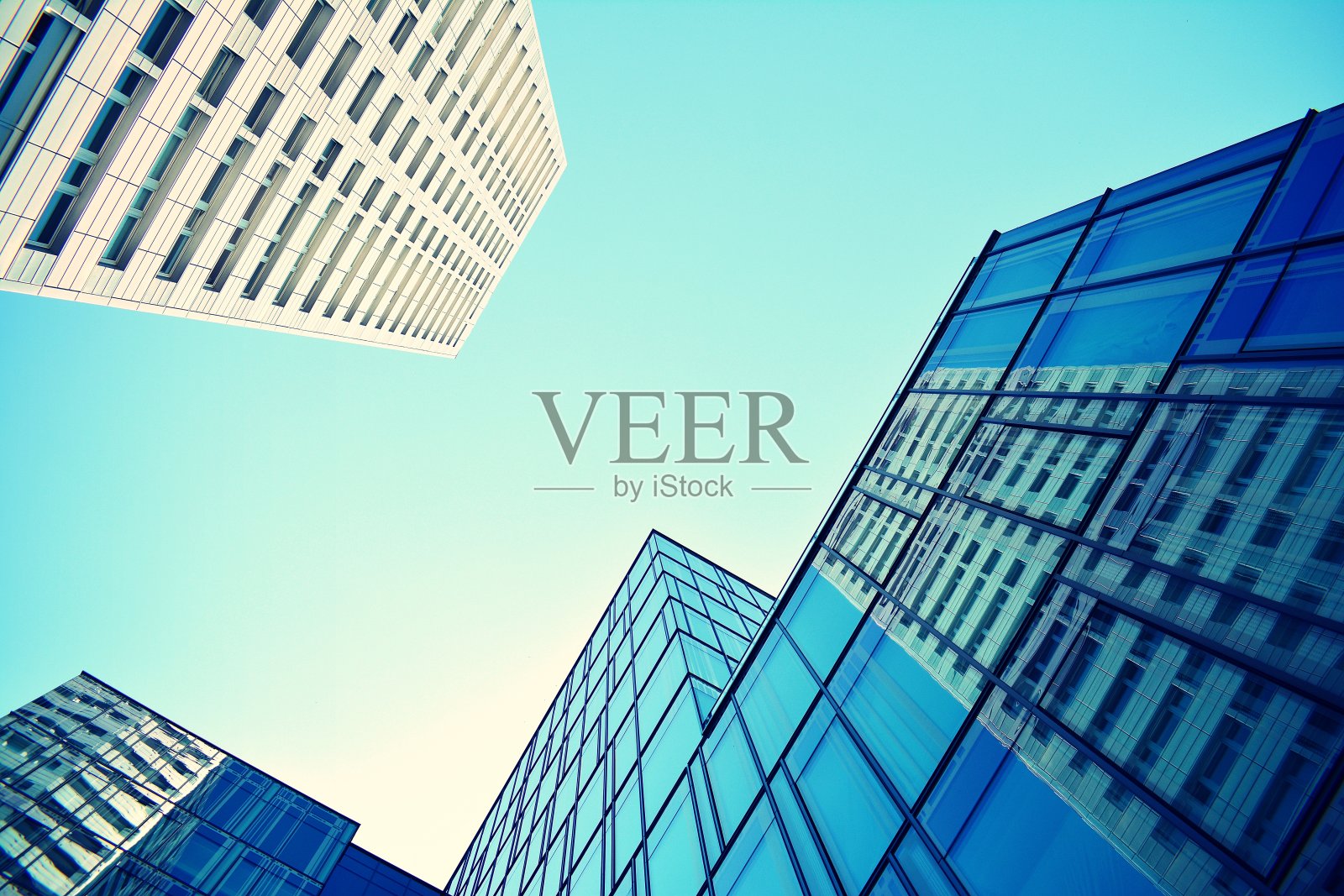 在晴朗的天空背景下的现代办公大楼。复古风格的彩色色调滤镜效果照片摄影图片