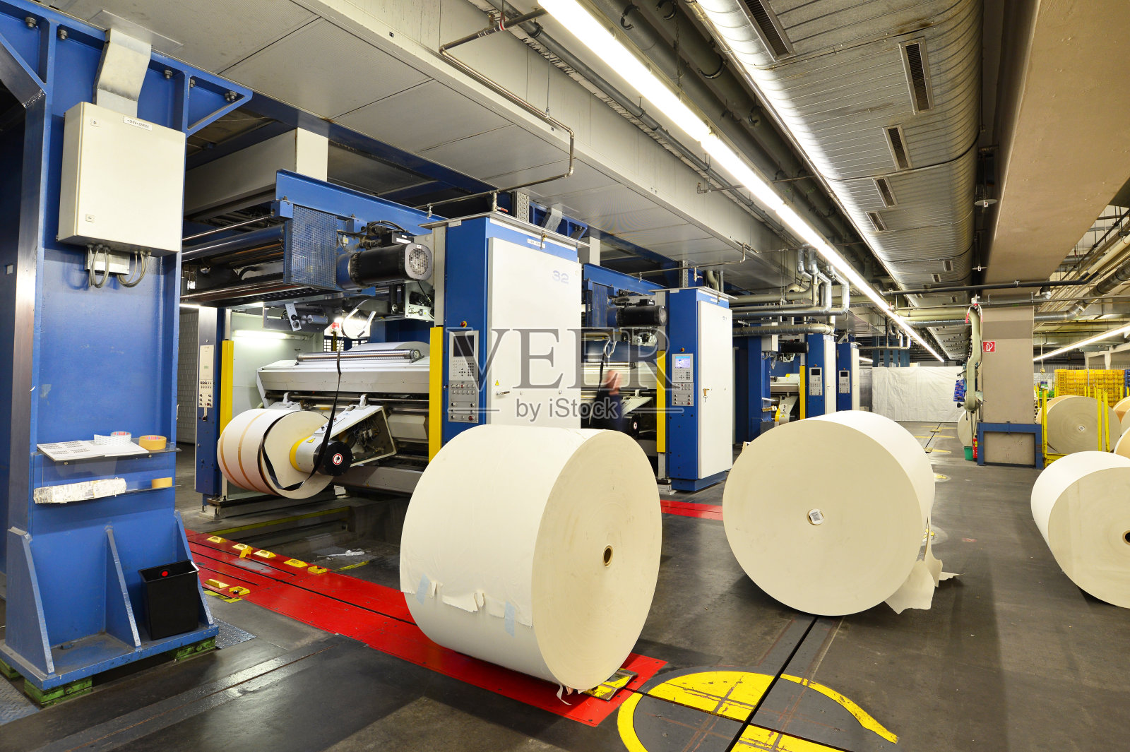 大型印刷车间的纸卷和胶印机，用于生产报纸和杂志照片摄影图片