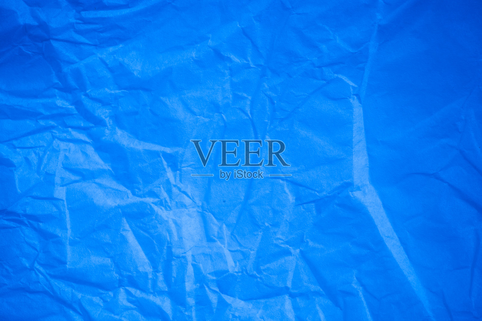 皱巴巴的蓝色纸背景。照片摄影图片