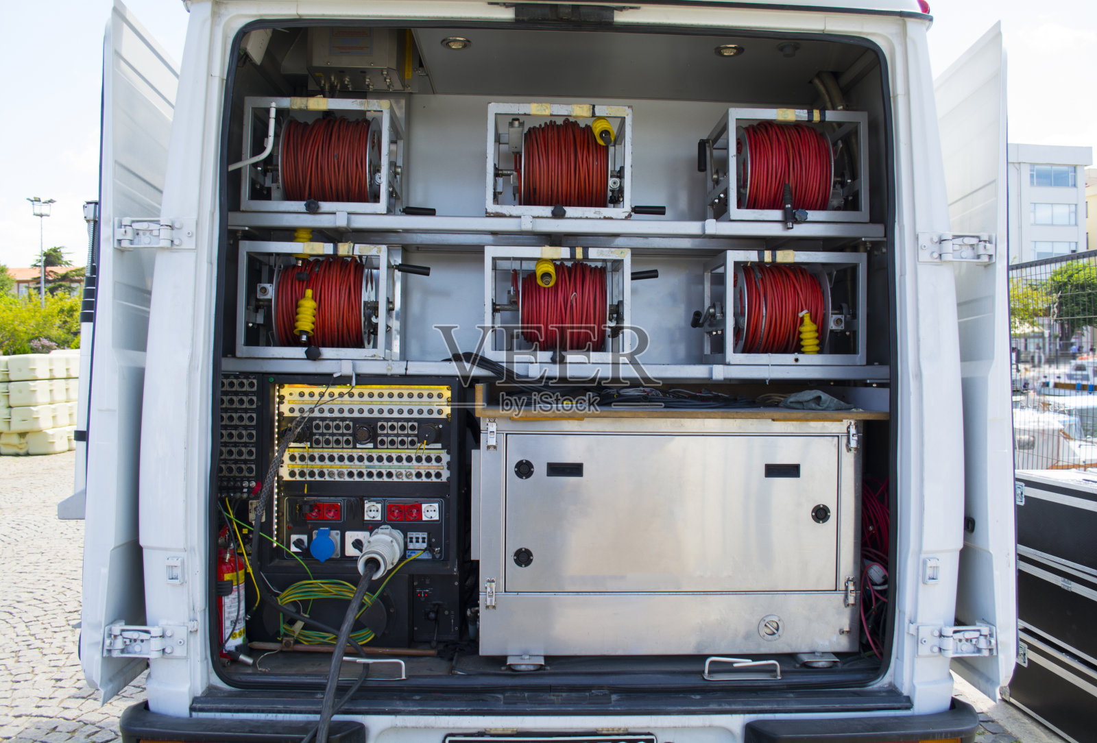 后面有传输线和电子电缆网，外面有广播车。照片摄影图片