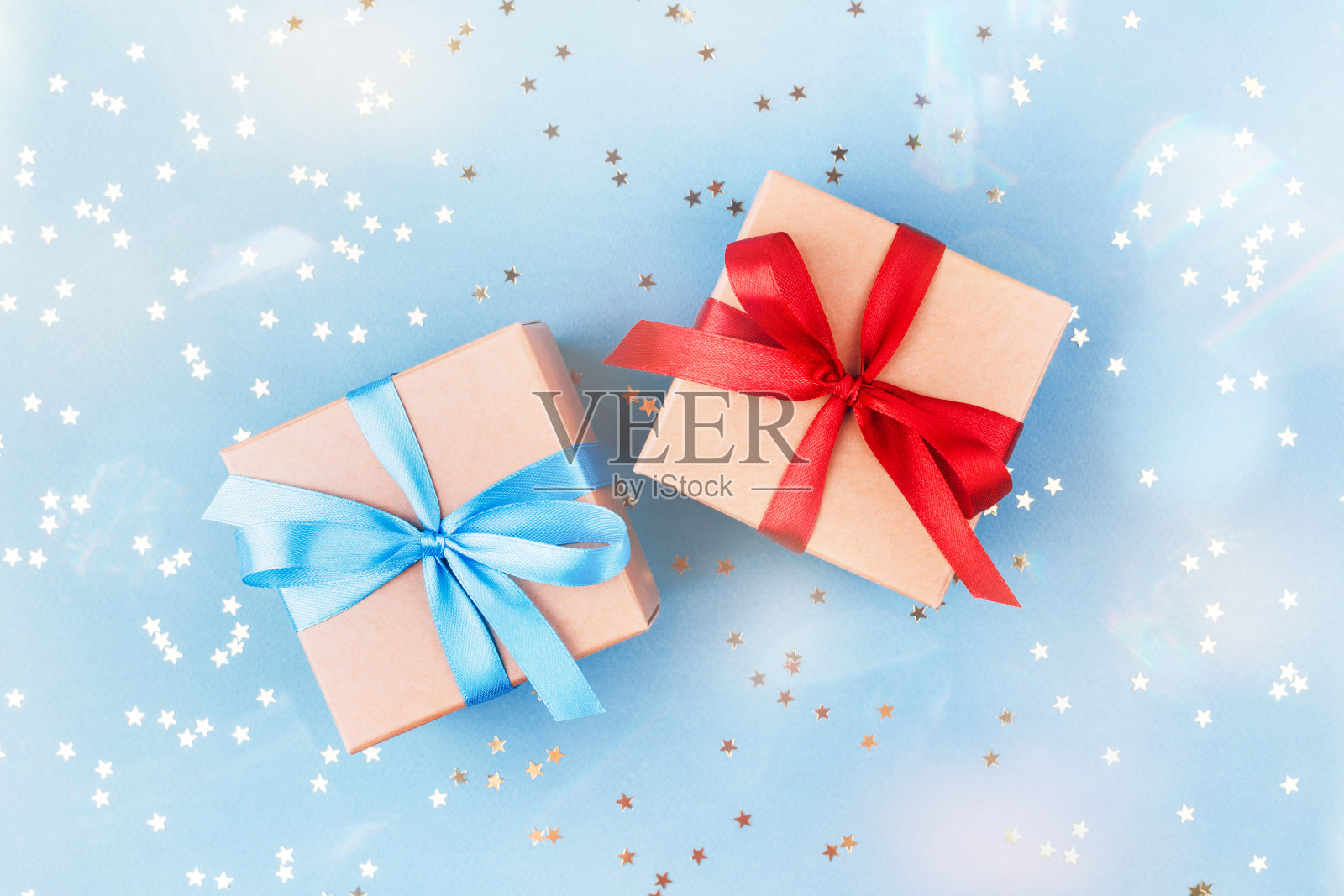 两个用牛皮纸和五彩纸屑包装的礼品盒。照片摄影图片