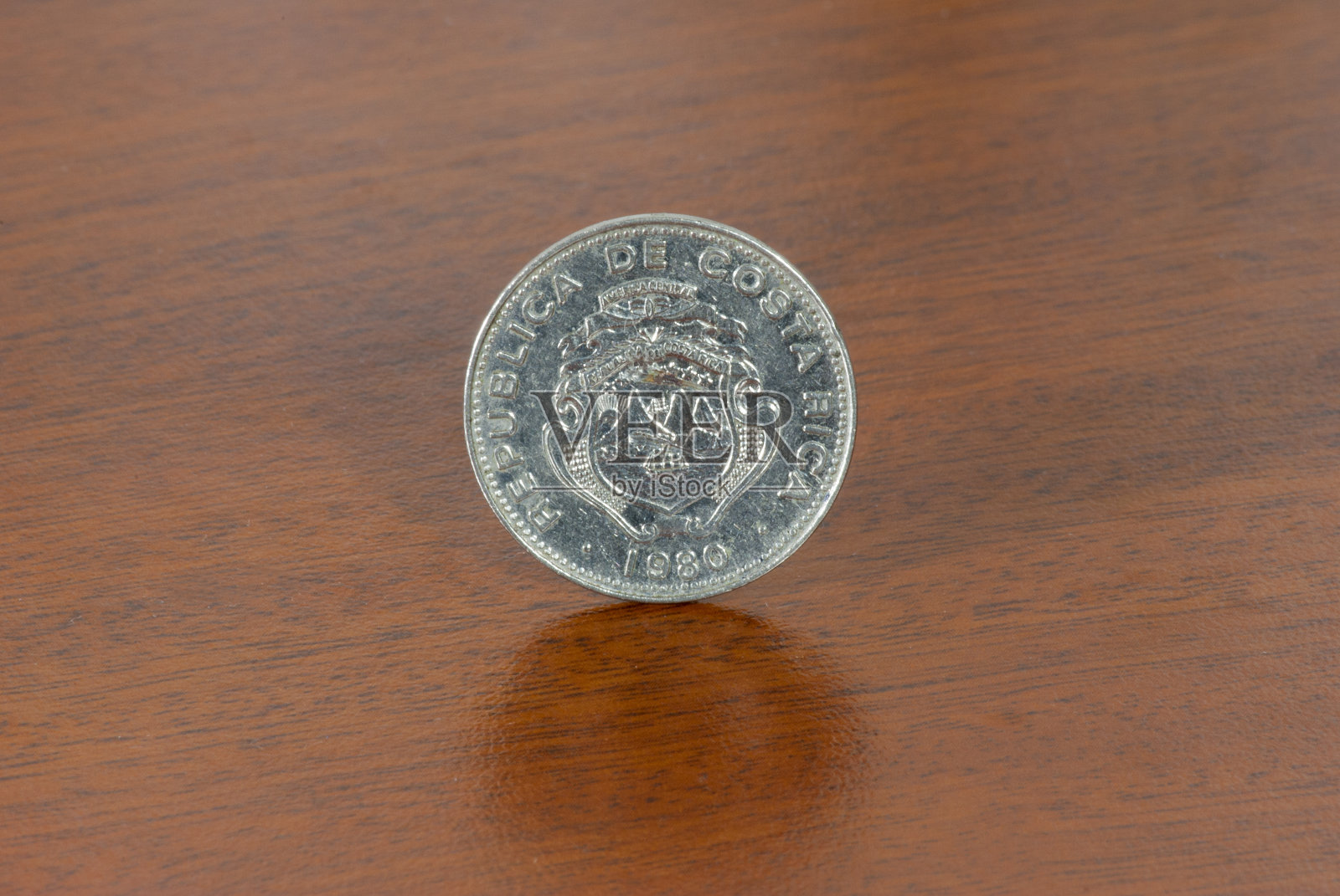 哥斯达黎加1980年版25分硬币，木纹背景上的货币照片摄影图片